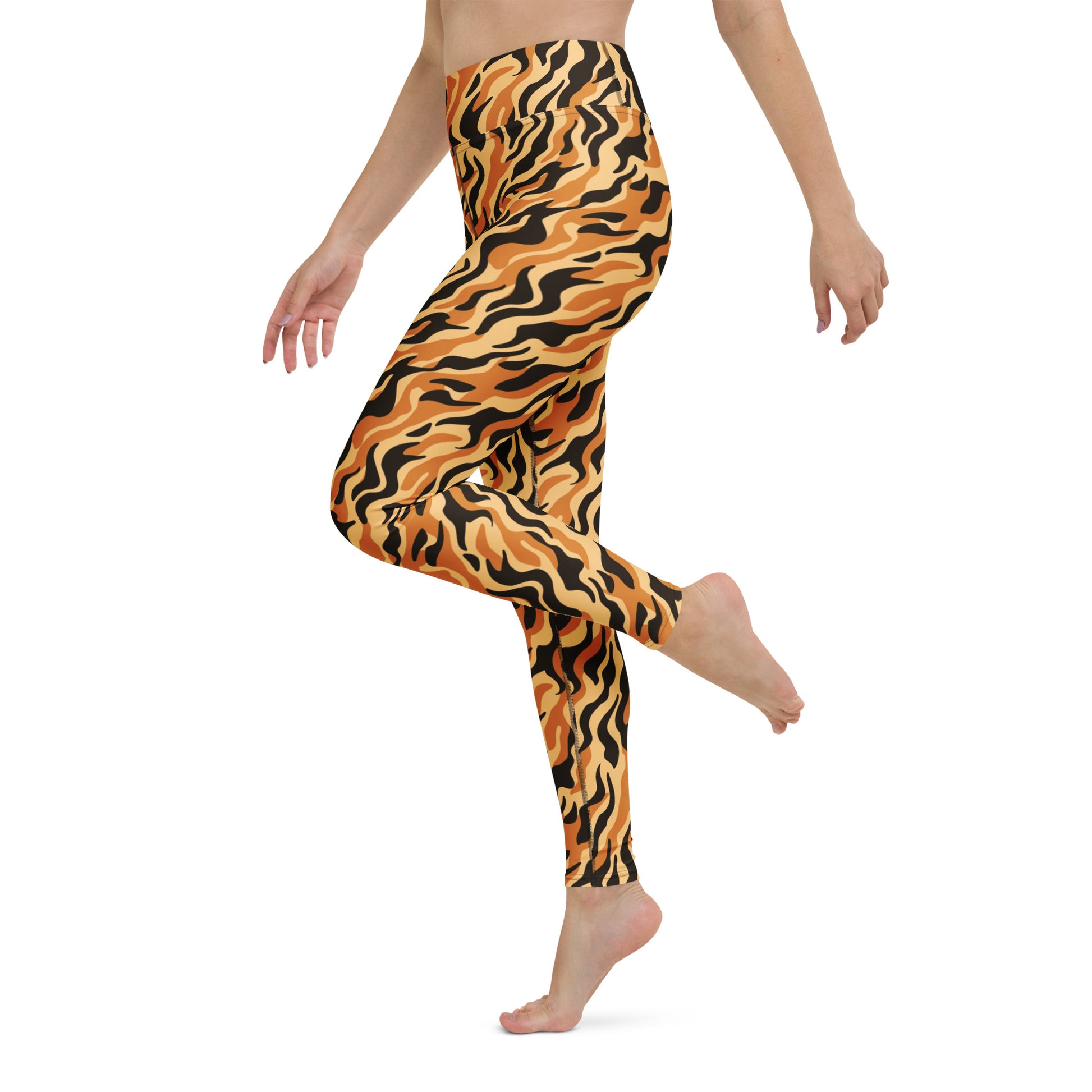 A model wearing high-waisted leggings with a bold orange, black, and tan wavy tiger-stripe pattern, shown from the waist down against a plain white background. Activewear Essentials: Tiger Print Yoga Pants