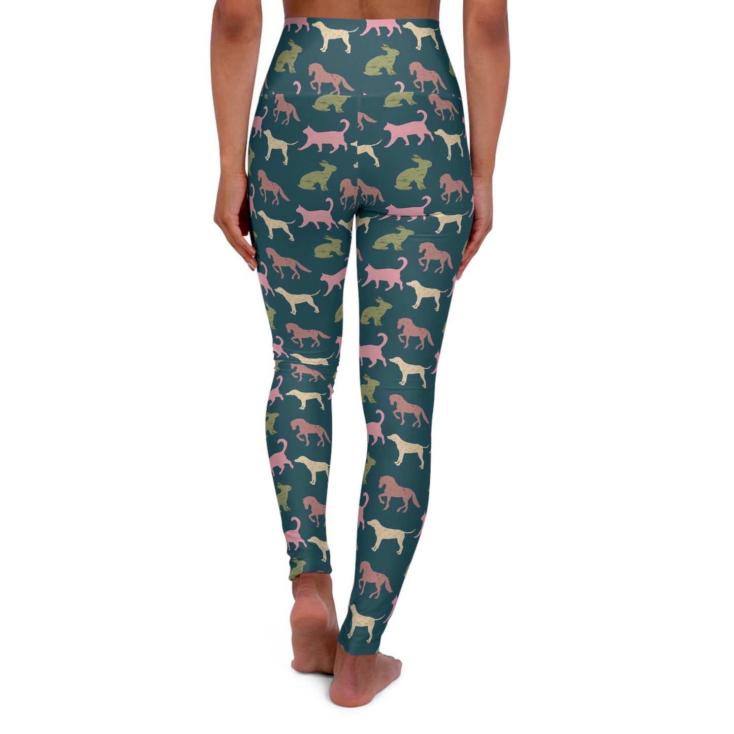 A person shown from the back wearing high-waisted leggings with an allover pattern of stylized dog silhouettes in pink, cream, and olive green on a dark teal background, against a plain white studio backdrop.