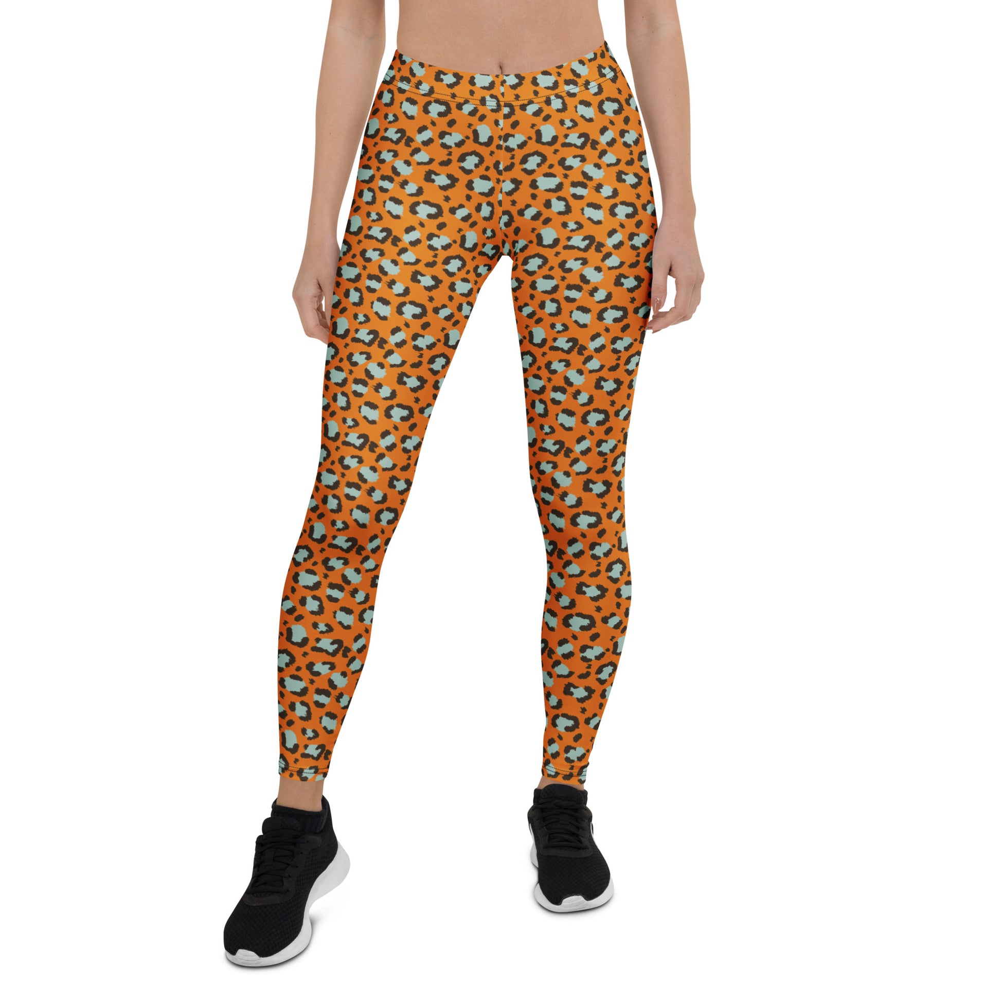 A model from the waist down wearing high-waisted leggings with an orange, black, and light blue abstract pattern, paired with black athletic shoes, on a solid white background. Bold Leopard Print Leggings: A Wardrobe Essential Activewear
