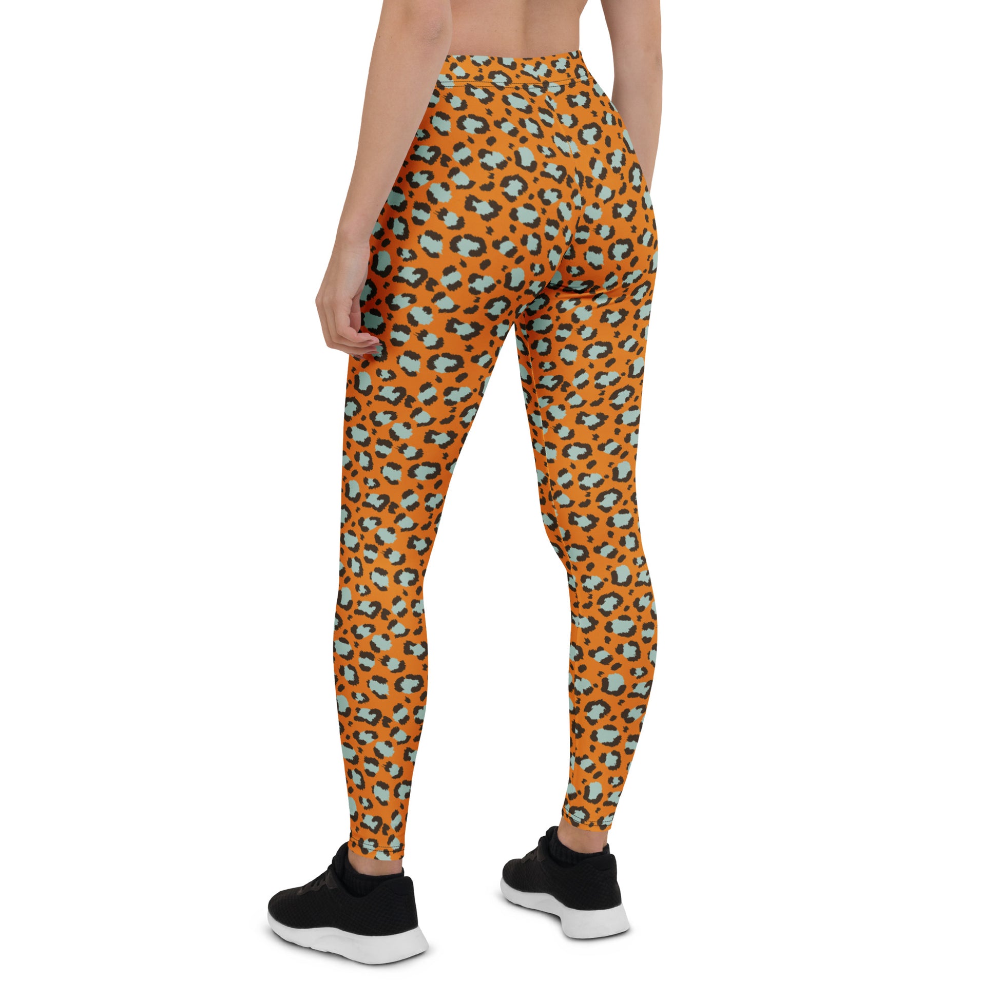 A model from the back wearing high-waisted leggings with an orange, black, and light blue leopard print pattern, paired with black sneakers on a white background. Bold Leopard Print Leggings: A Wardrobe Essential for Activewear