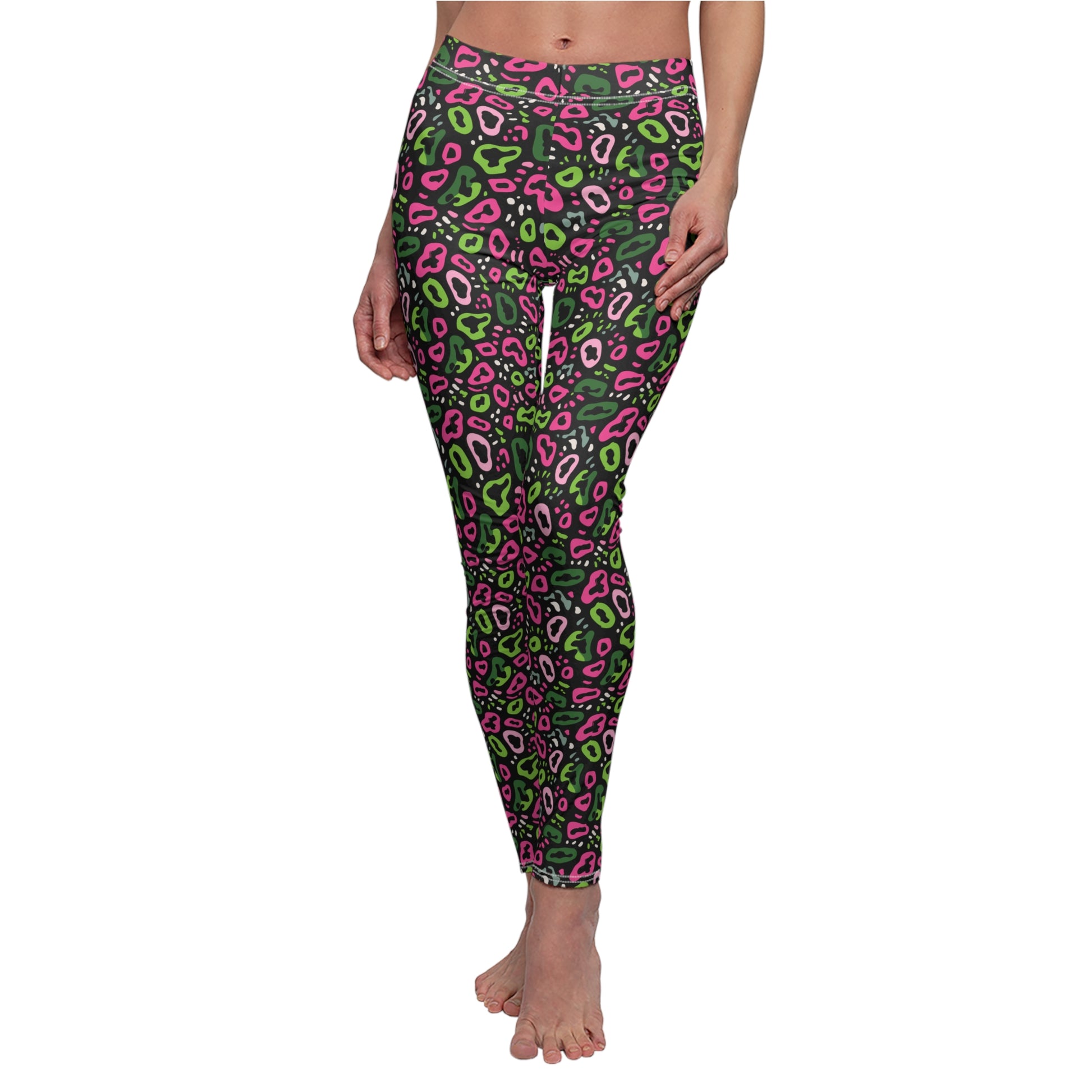 A person modeling high-waisted leggings with a dark green base and an all-over abstract paisley-style pattern in bright pink, lime green, and white, shown against a plain white background. Bold Neon Pink and Green Leopard Print Leggings