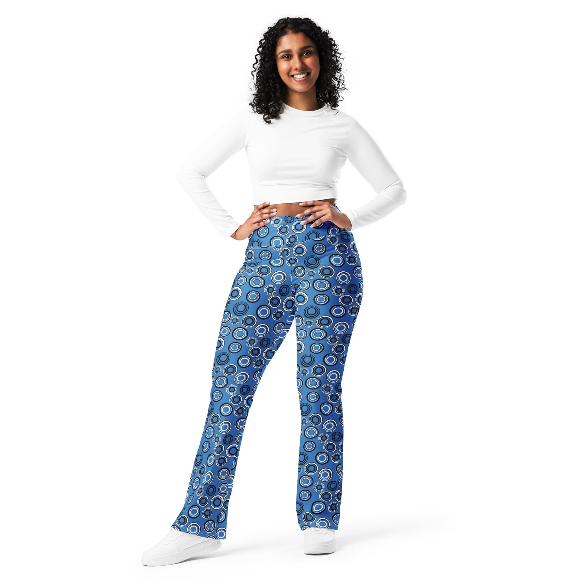 Woman wearing blue patterned leggings and a white long-sleeve top on a white background Celestial Planetary Orbit Pattern Flare Leggings Activewear