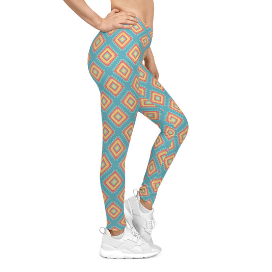 A person wearing high-waisted leggings with a geometric diamond pattern in turquoise blue, orange, and white, paired with white sneakers against a plain white background.