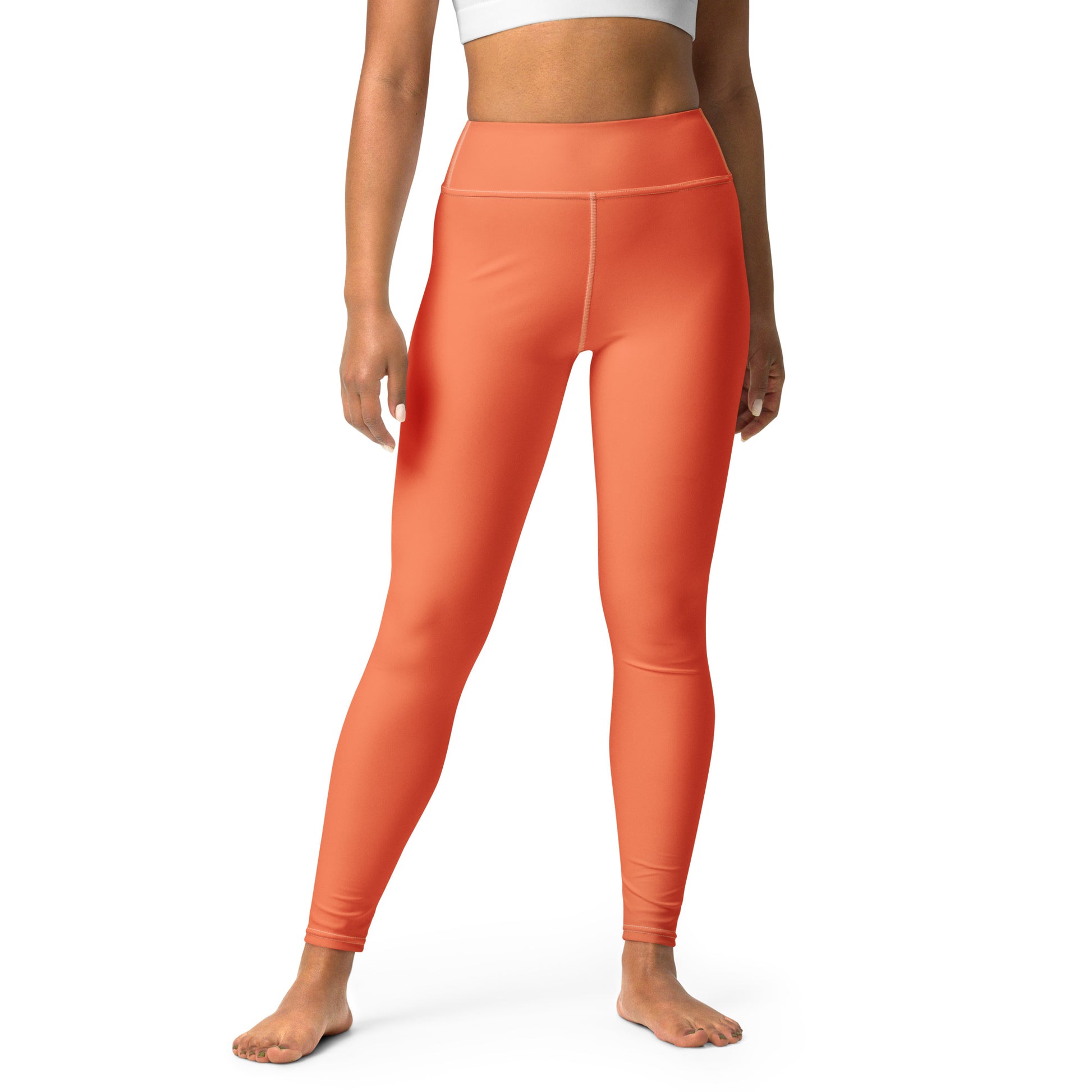 A model wearing bright orange high-waisted leggings, shown from the waist down against a plain white background. Chic Comfortable Yoga Pants in Solid Coral Shade Activewear