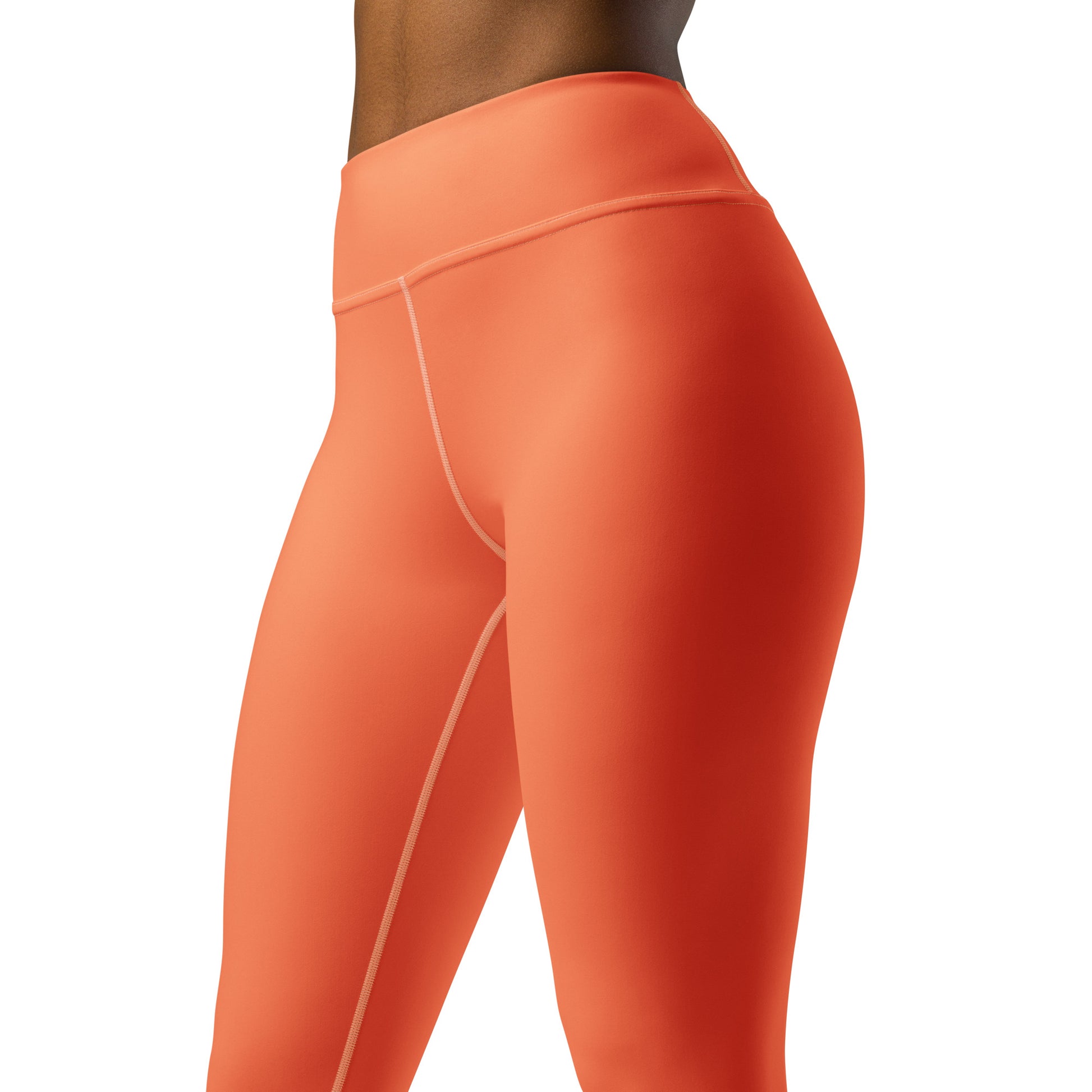 Close-up side view of a person wearing bright coral-orange high-waisted leggings against a plain white background. Chic Comfortable Yoga Pants in Solid Coral Shade for Activewear