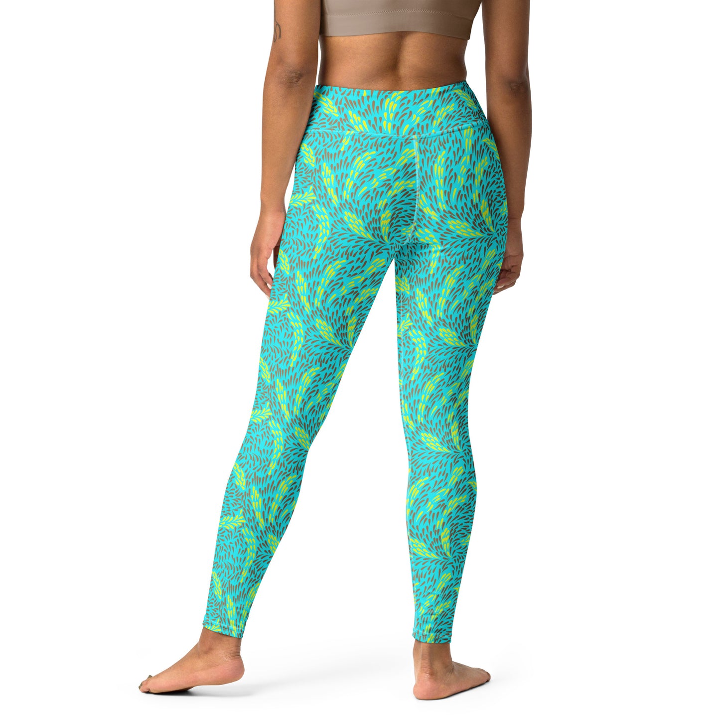 A model wearing high-waisted leggings with a vibrant turquoise and lime green abstract pattern, shown from the back against a plain white background. 