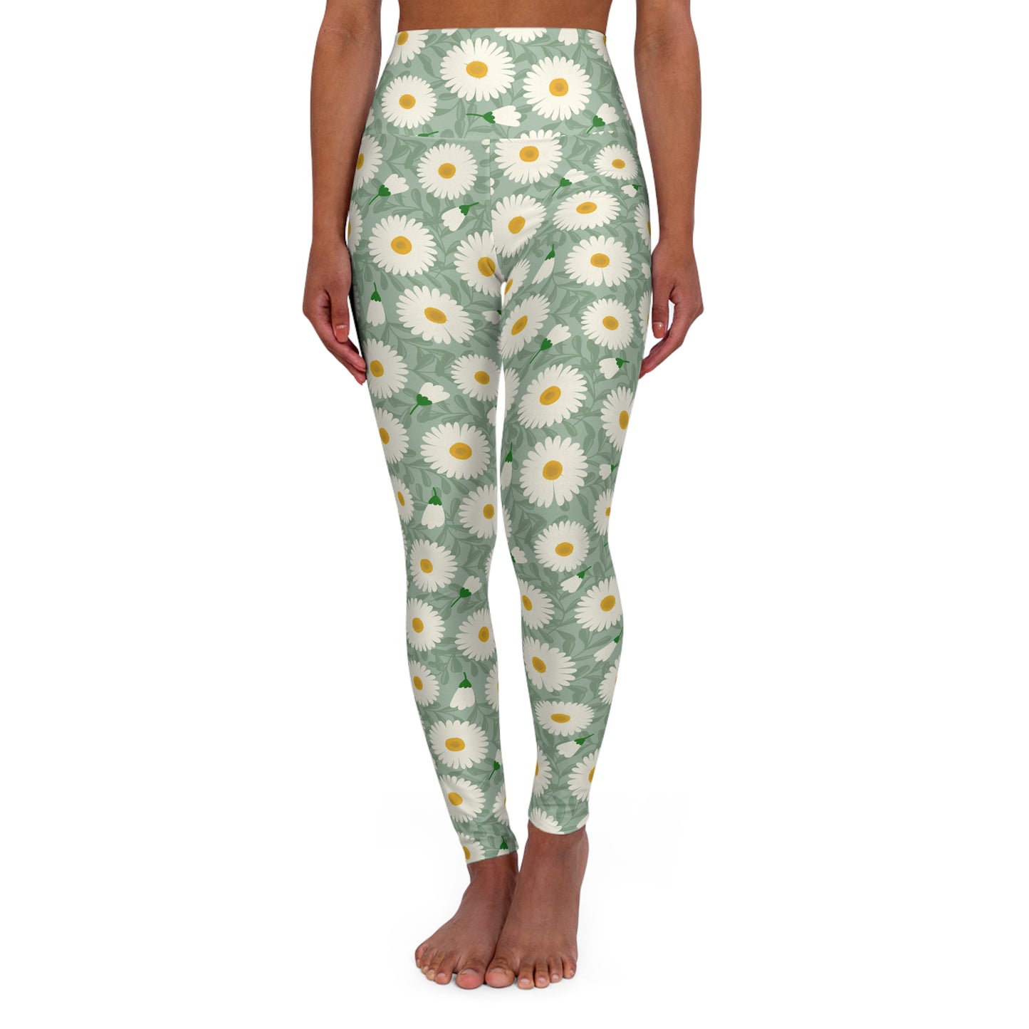 A model is shown from the waist down wearing high-waisted leggings with a green background and a white and yellow daisy floral pattern, standing barefoot against a white background.