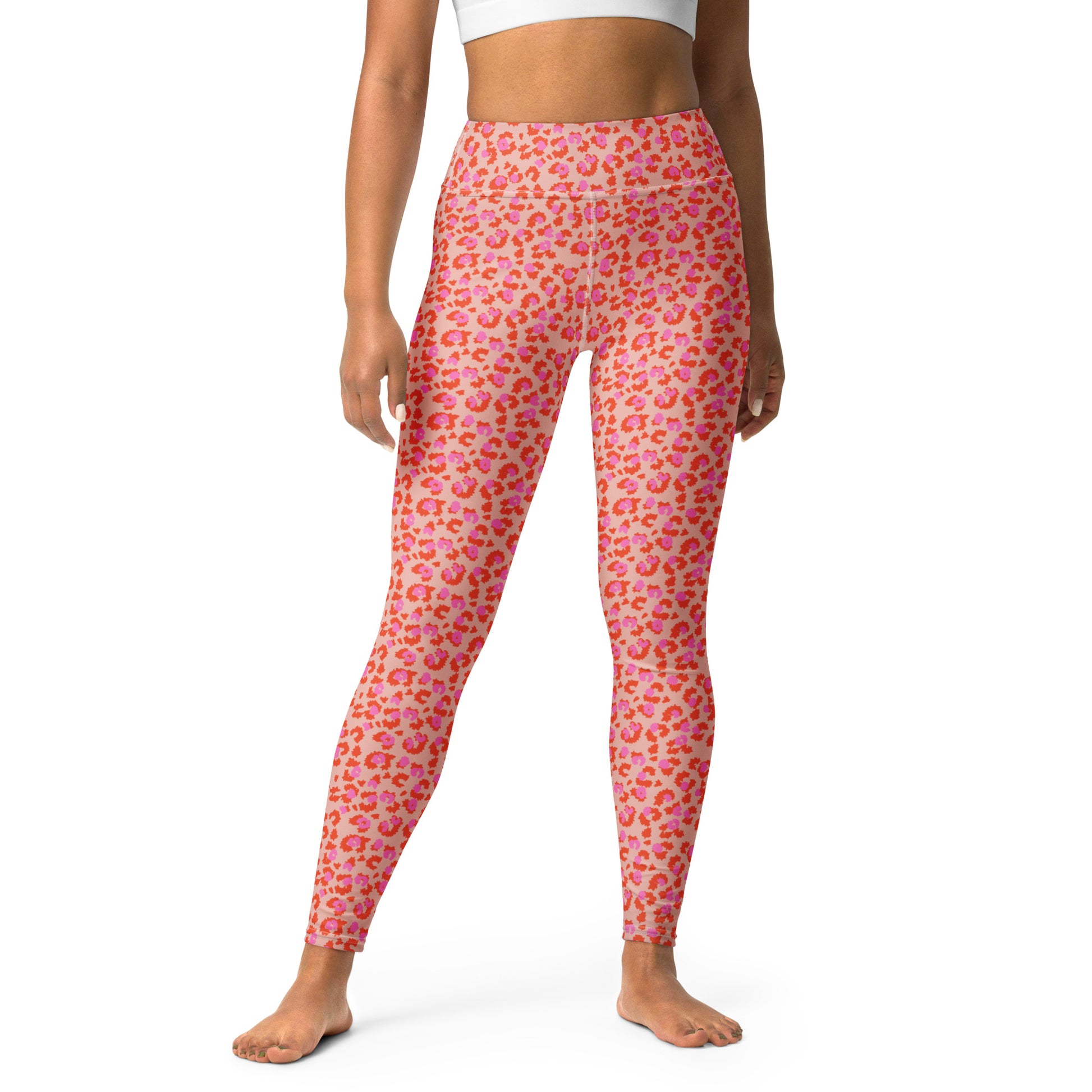 Pink leopard-print leggings with orange and yellow spots, modeled on a person against a plain white background. Chic Pink Leopard Print Yoga Pants for Workouts