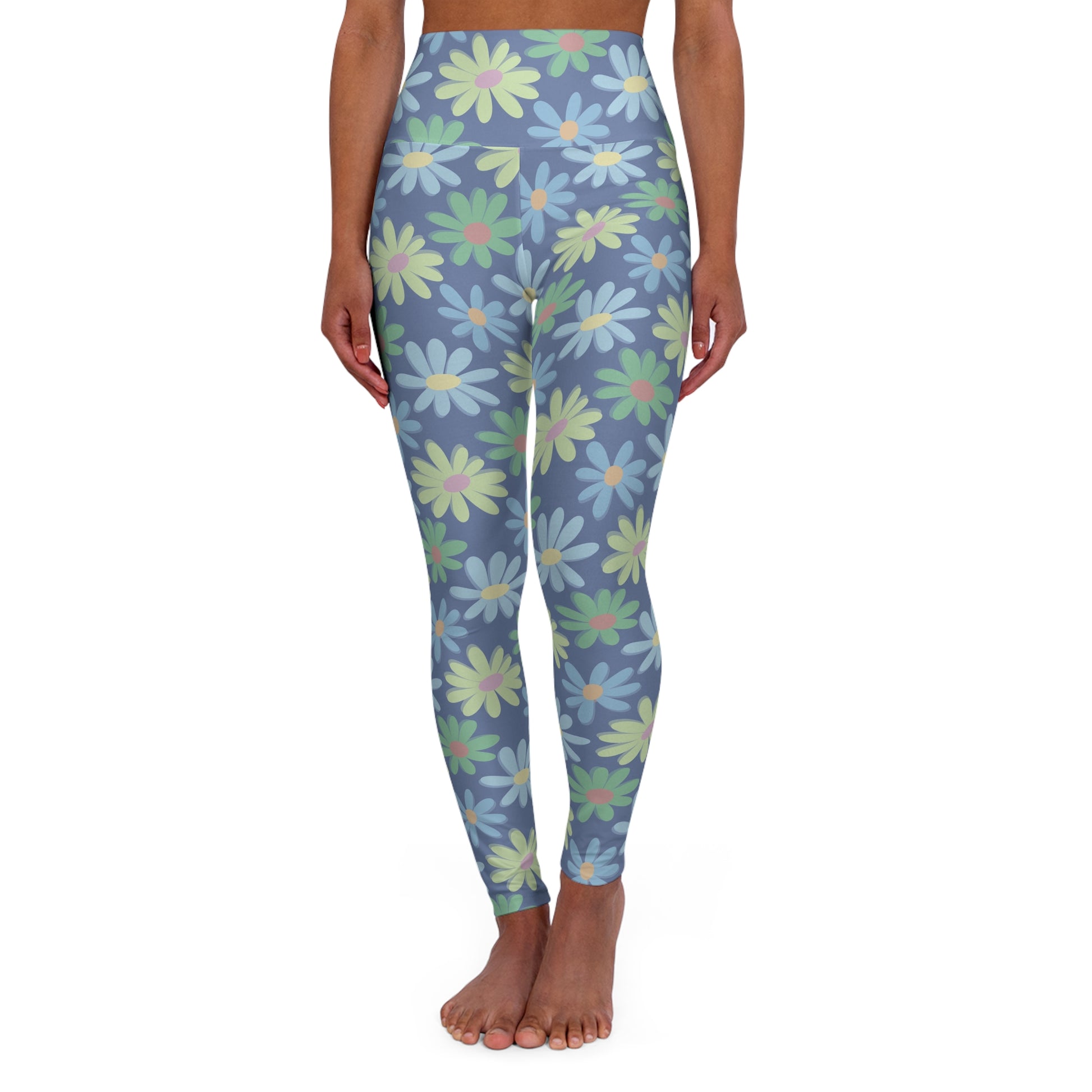 A model is shown from the waist down wearing high-waisted leggings with a blue-gray background and a repeating pattern of large daisy flowers in light blue, mint green, and pale yellow.