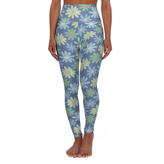 A model is shown from the waist down wearing high-waisted leggings with a blue-gray background and a repeating pattern of large daisy flowers in light blue, mint green, and pale yellow.
