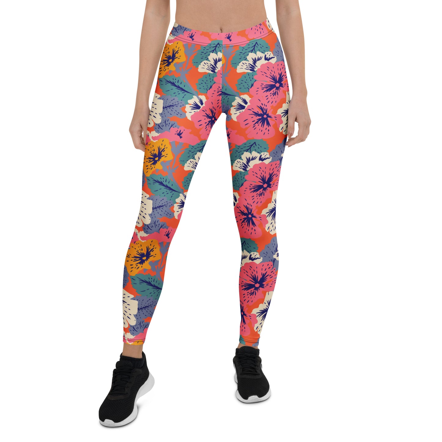 A model wearing colorful floral print leggings with a vibrant pattern of pink, orange, blue, and yellow flowers on a coral background, paired with black athletic shoes, shot against a plain white background. Colorful Bold Floral Leggings with Tropical Twist