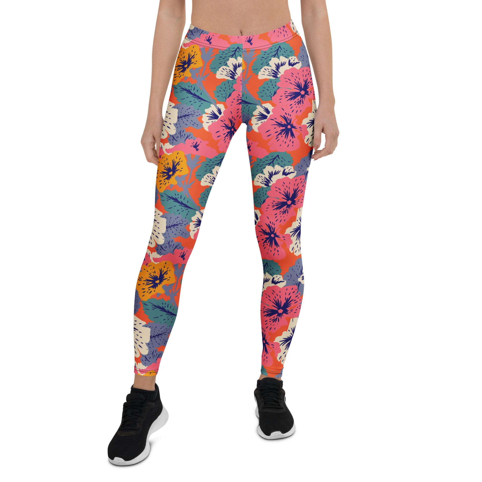 A model wearing colorful floral print leggings with a vibrant pattern of pink, orange, blue, and yellow flowers on a coral background, paired with black athletic shoes, shot against a plain white background. Colorful Bold Floral Leggings with Tropical Twist