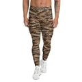 A model from the waist down wearing high-waisted, slim-fit leggings with a brown and black tiger-stripe camouflage pattern, paired with white sneakers, on a solid white background. Comfortable Bold Brown Tiger Stripes Men's Athletic Leggings