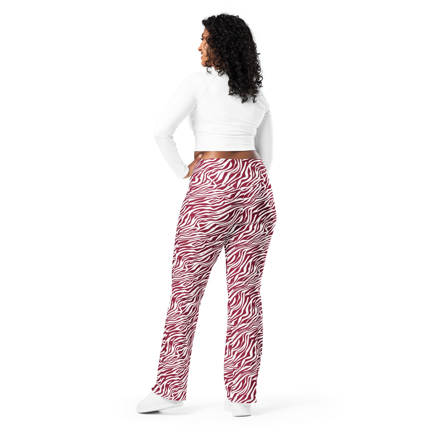 A woman shown from the back wearing red and white zebra-print pants, a white long-sleeve crop top, and white sneakers against a plain white background. Comfortable Bold Red Zebra Print Flare Leggings