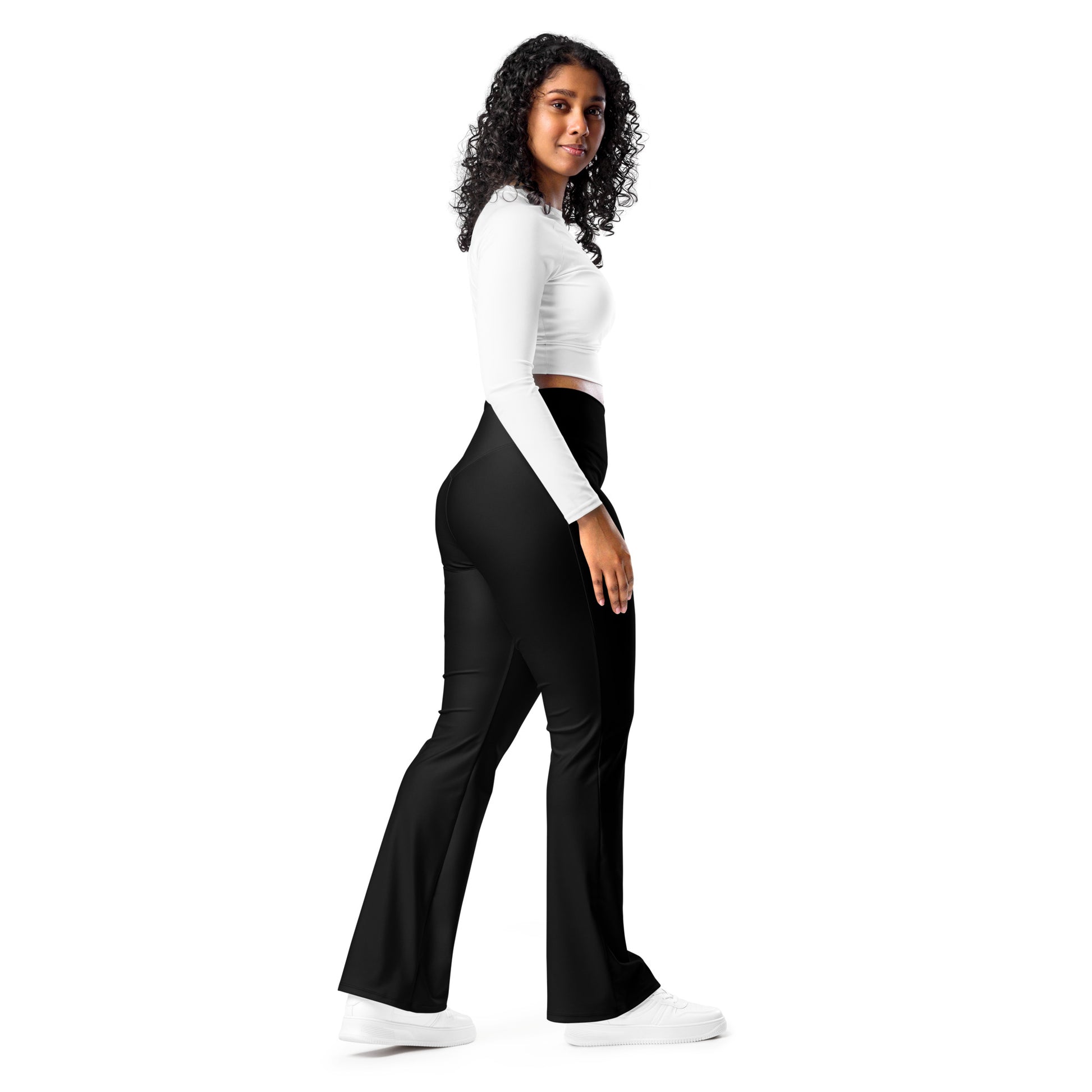 Woman wearing a white long-sleeve top and black pants with branding on a white background Comfortable Minimalist Solid Black Flare Leggings for Activewear