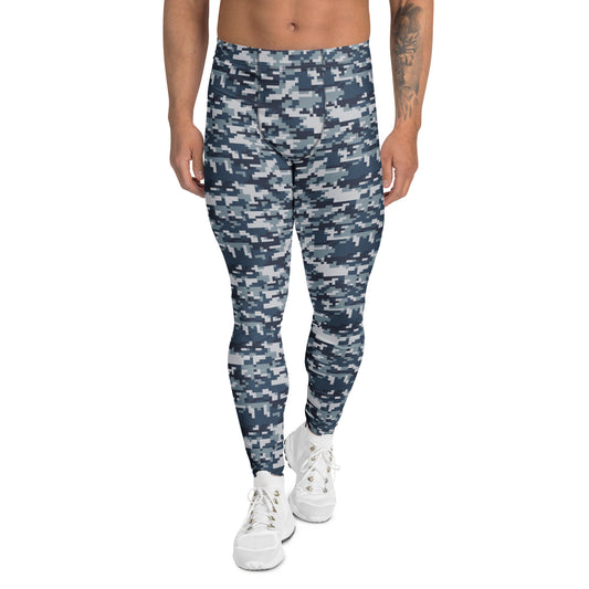 A person modeling slim-fit jogger pants with a blue and gray digital camouflage pattern, paired with white sneakers, against a plain white background.