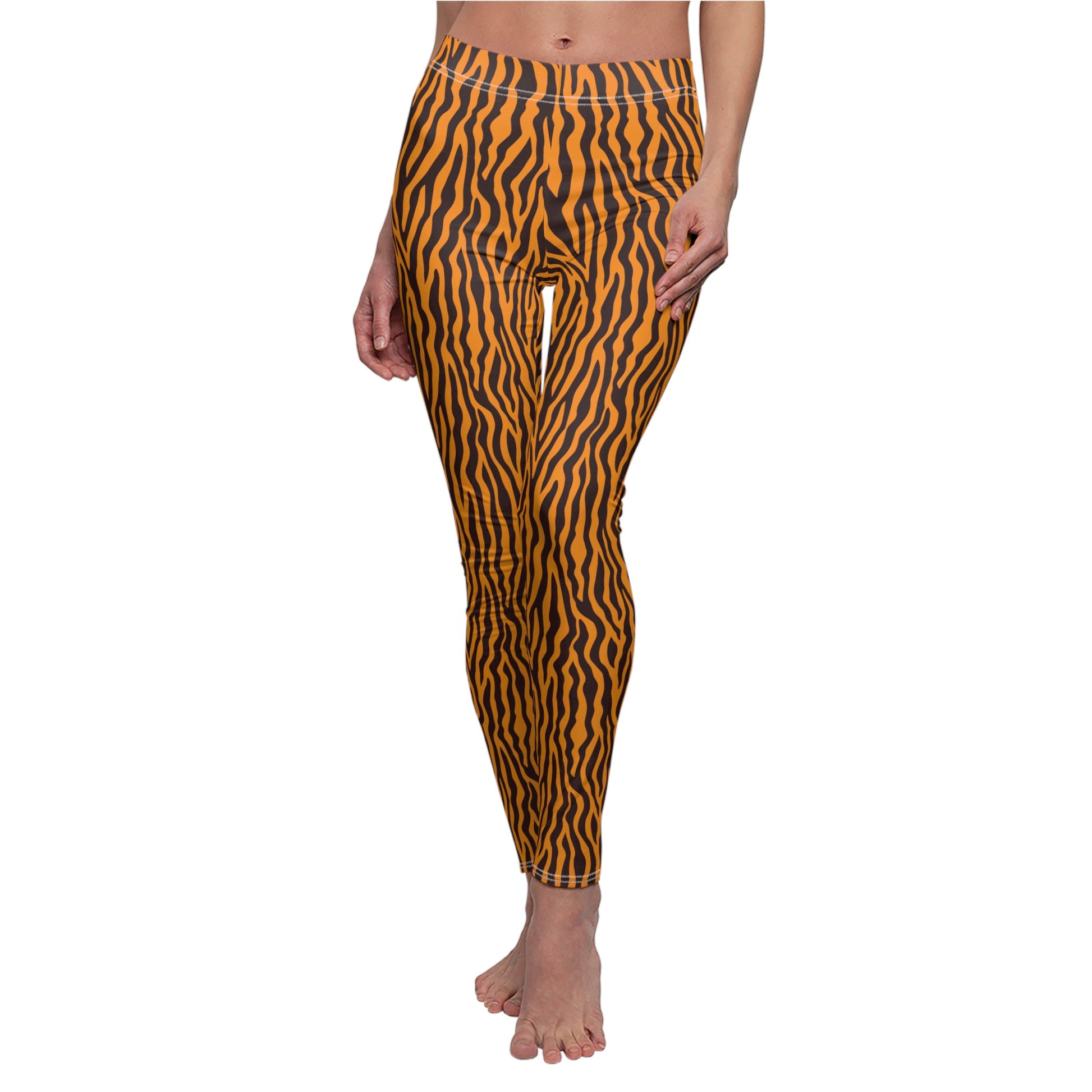 A model is shown from the waist down wearing high-waisted leggings with a bold orange and black wavy animal print pattern, set against a plain white background. Comfortable Tiger Print Leggings in Bold Orange