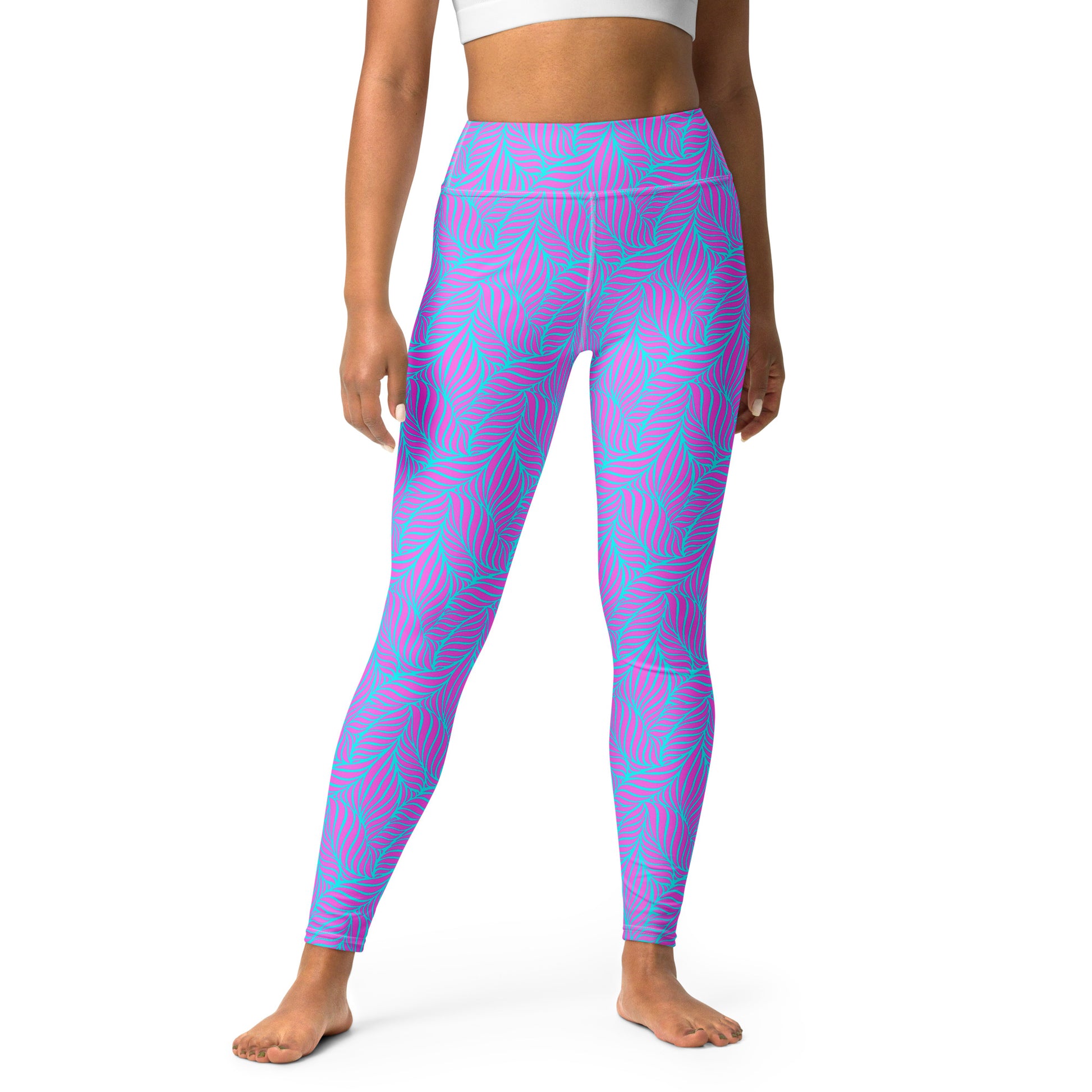 A model wearing high-waisted leggings with a vibrant pink and turquoise palm leaf pattern, shown from the waist down on a solid white background. Contemporary Bold Neon Tropical Yoga Leggings