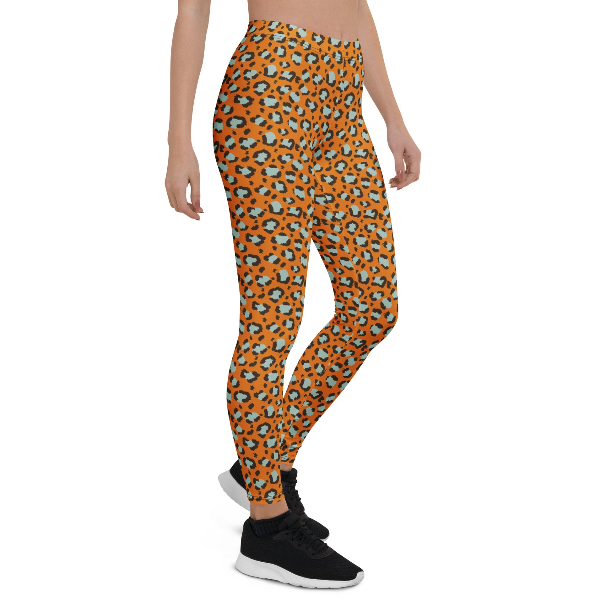 A model wearing high-waisted leggings with an orange and black leopard print pattern, paired with black sneakers, shown from the waist down on a white background. Cute Bold Leopard Print Leggings: A Wardrobe Essential Activewear