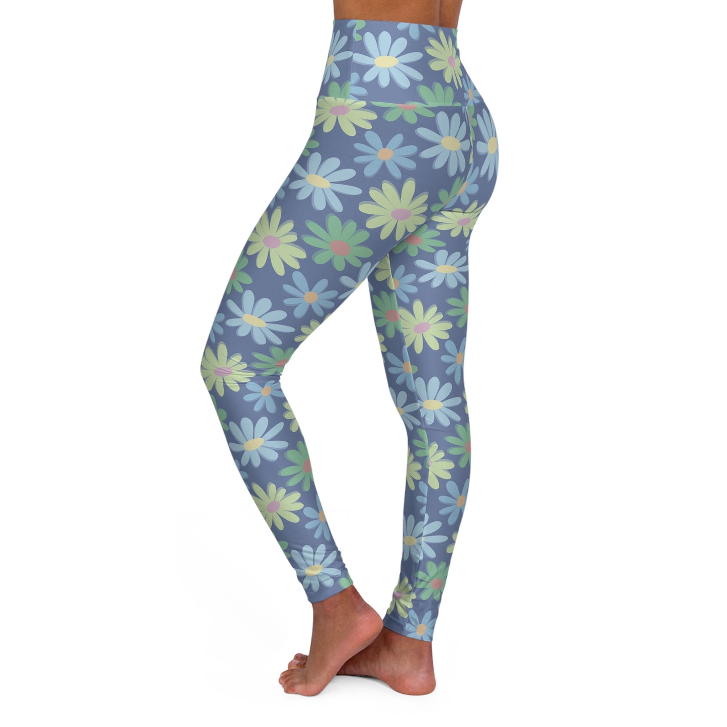 A side view of a person wearing high-waisted leggings with a blue-gray base and a repeating daisy pattern in light blue, mint green, and pale yellow, shown against a plain white background.