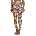 A person modeling high-waisted leggings with a colorful abstract pattern of overlapping oval and circular shapes in red, yellow, blue, black, and gray on a light beige background, shown against a plain white studio backdrop. Minimalist Bauhaus Geometric Print Yoga Leggings