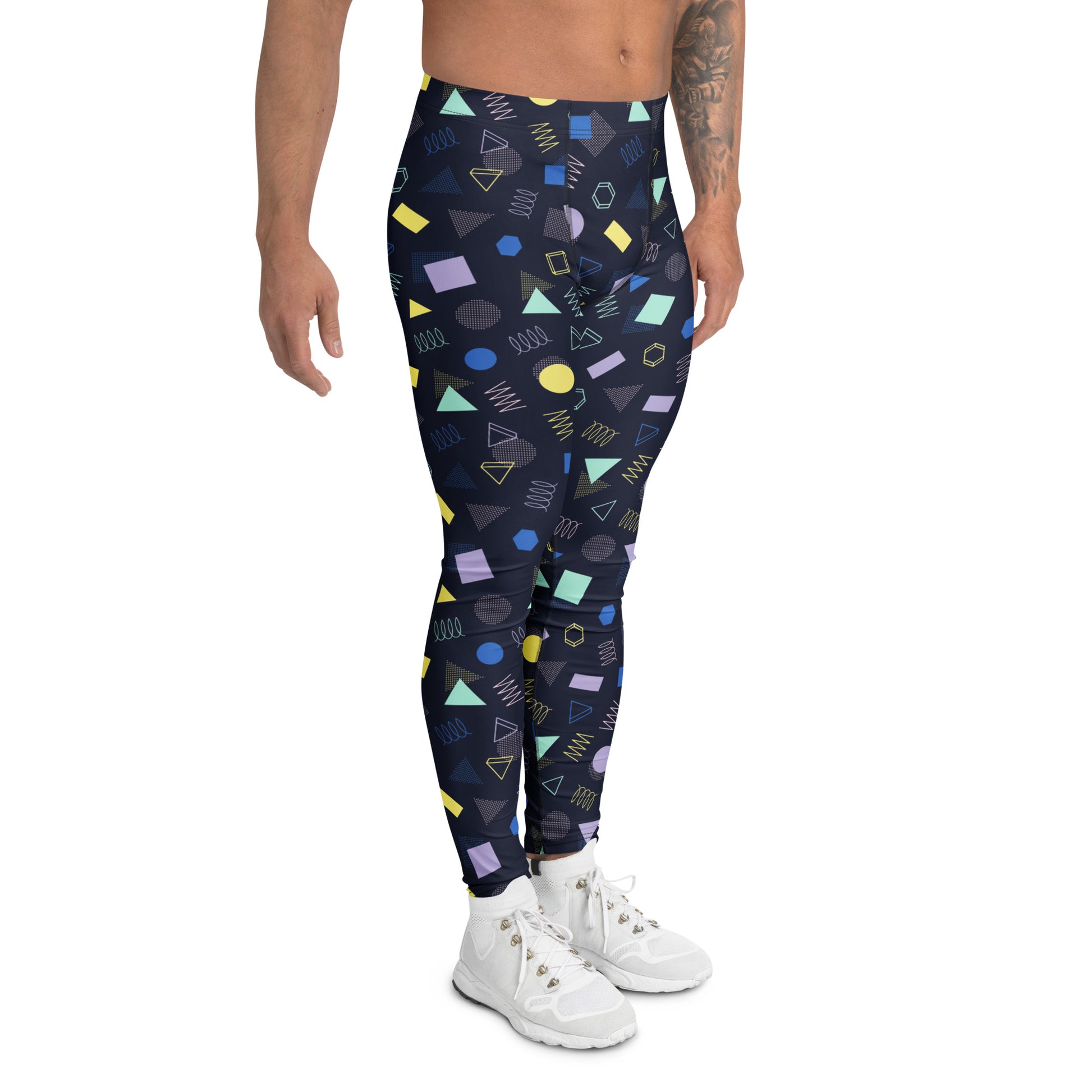 A person modeling high-waisted leggings with a colorful geometric pattern on a plain white background. The leggings feature a navy base with shapes in yellow, green, purple, and blue. Minimalist Bold Aesthetic Geometric Memphis Men's Leggings for Activewear