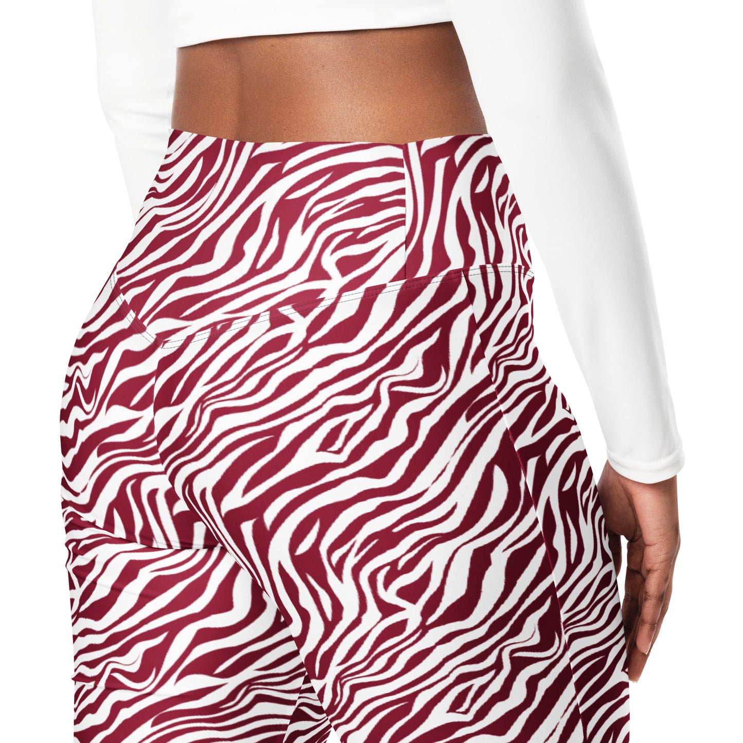 A close-up of a model wearing high-waisted athletic leggings with a bold red and white wavy zebra-like pattern, paired with a white long-sleeve crop top against a plain white background. Modern Comfortable Bold Red Zebra Print Flare Leggings Activewear