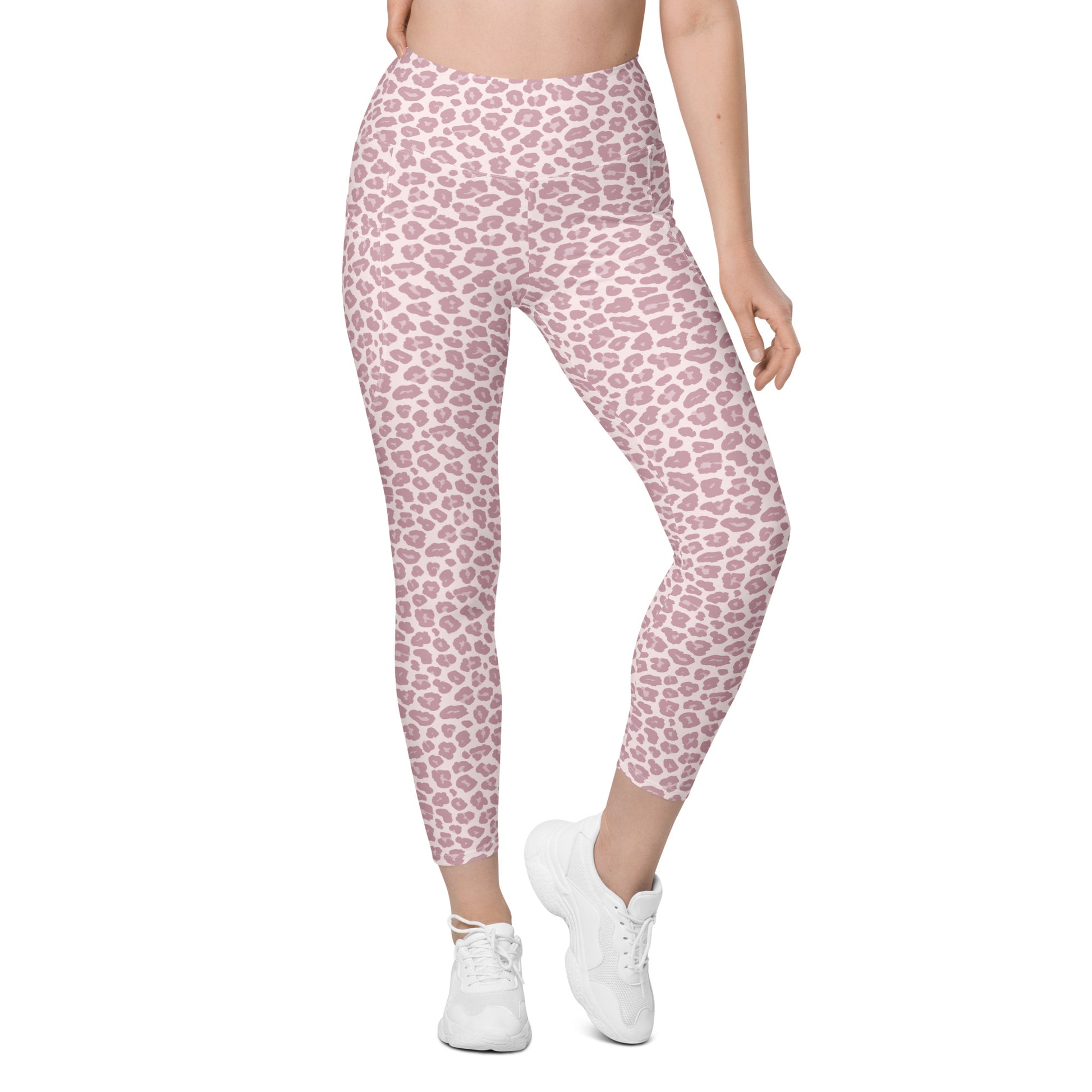 A model from the waist down wearing high-waisted leggings with a pink and white leopard print pattern, paired with white sneakers, on a solid white background. Modern Pink Pastel Leopard Print Leggings with Pockets Activewear