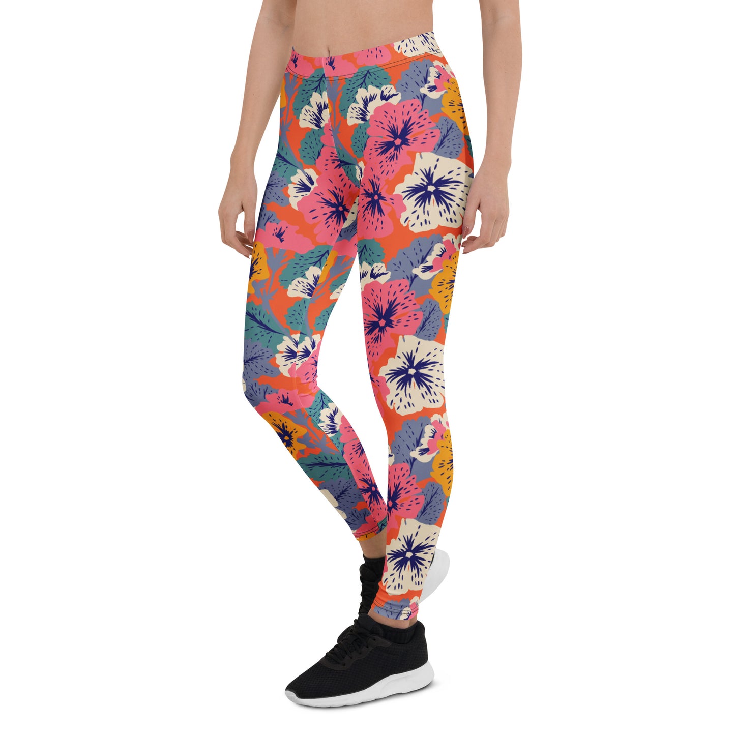 A person modeling high-waisted leggings with a bold multicolor floral and abstract print in pink, orange, blue, purple, and white, paired with black sneakers against a plain white background. Modern Tropical Leggings Featuring Bold Floral Patterns