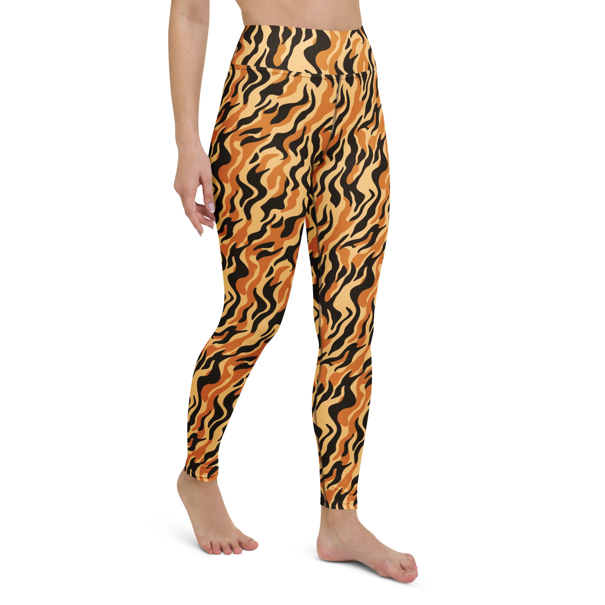 A model wearing high-waisted leggings with a bold wavy tiger-stripe pattern in orange, black, and yellow, shown from the waist down on a white background. Modern Yoga Pants Featuring Eye-Catching Tiger Prints