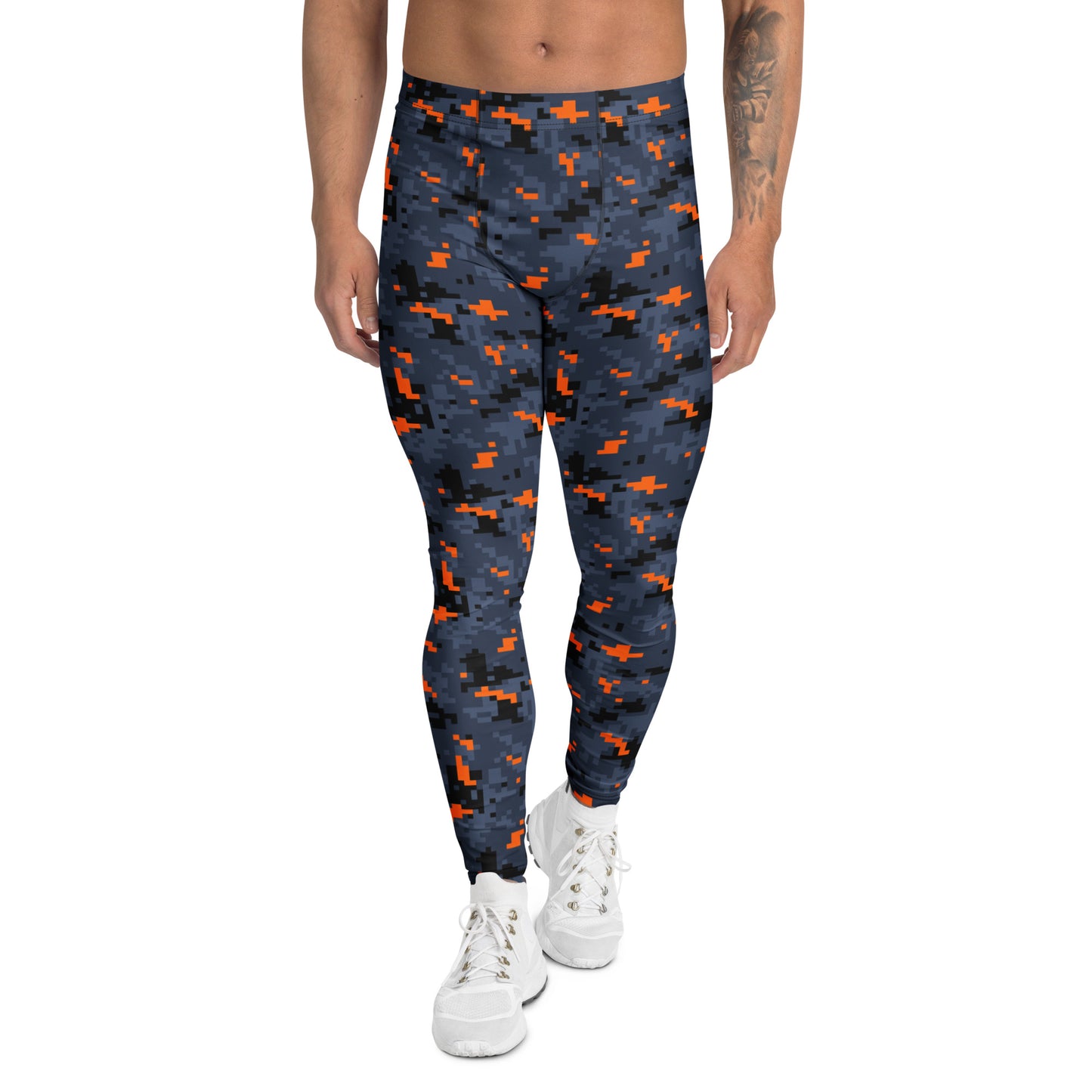 A person modeling high-waisted leggings with a dark navy blue and black pixelated camouflage pattern accented by bright orange shapes, paired with white sneakers against a plain white background.