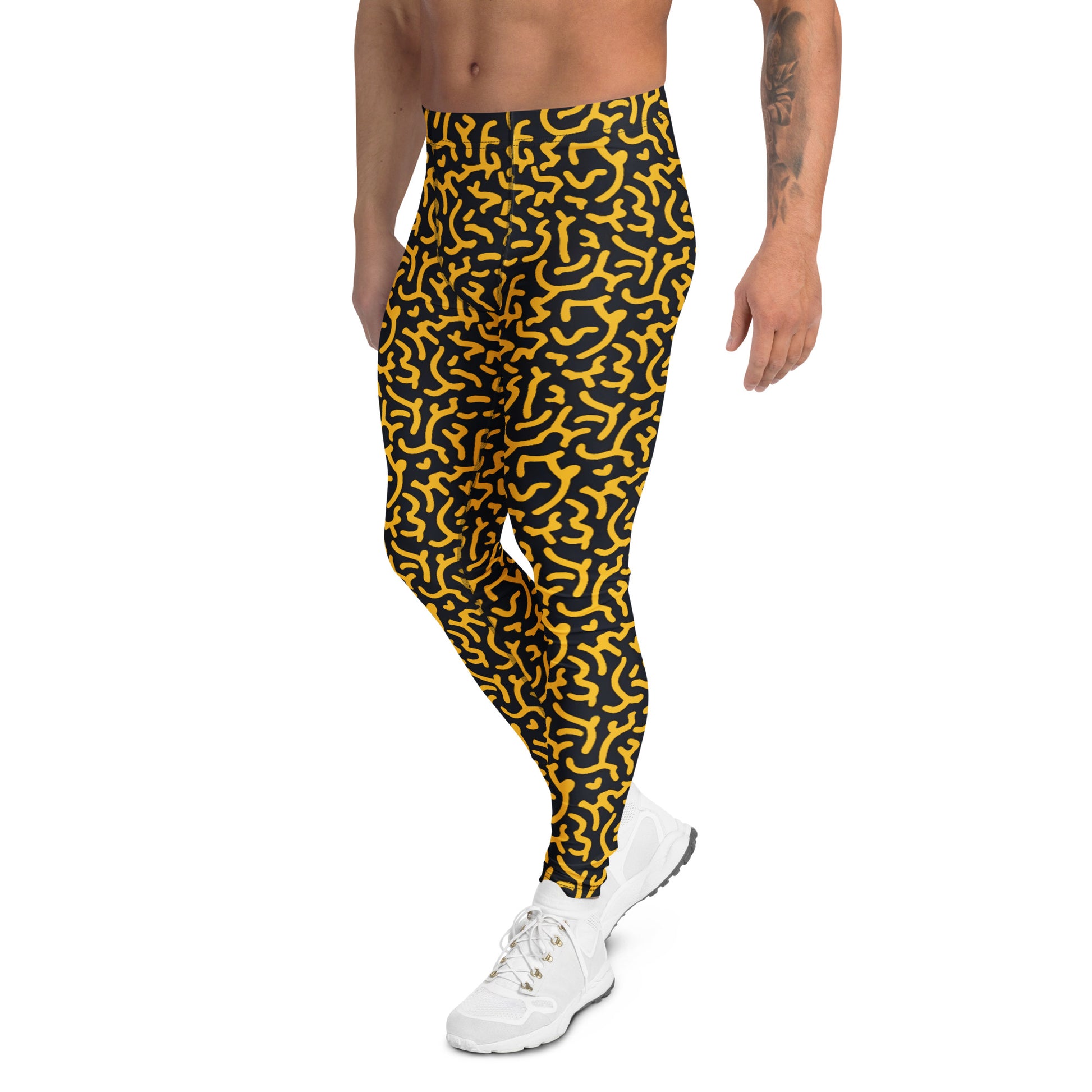 A person modeling high-waisted athletic pants with a bold yellow and black abstract maze-like pattern, paired with white sneakers against a plain white background. Premium Bold Gold Geometric Leggings for Men's Activewear Contemporary