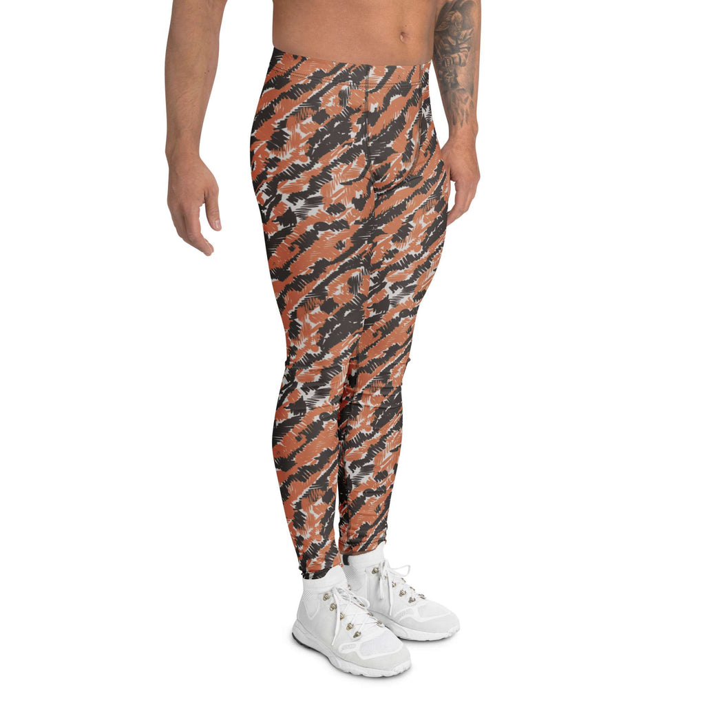 A model wearing high-waisted athletic leggings with a bold orange, black, and gray tiger-stripe camouflage pattern, paired with white sneakers, shown against a plain white background. Stylish Bold Artistic Brush Stroke Pattern Men's Athletic Leggings
