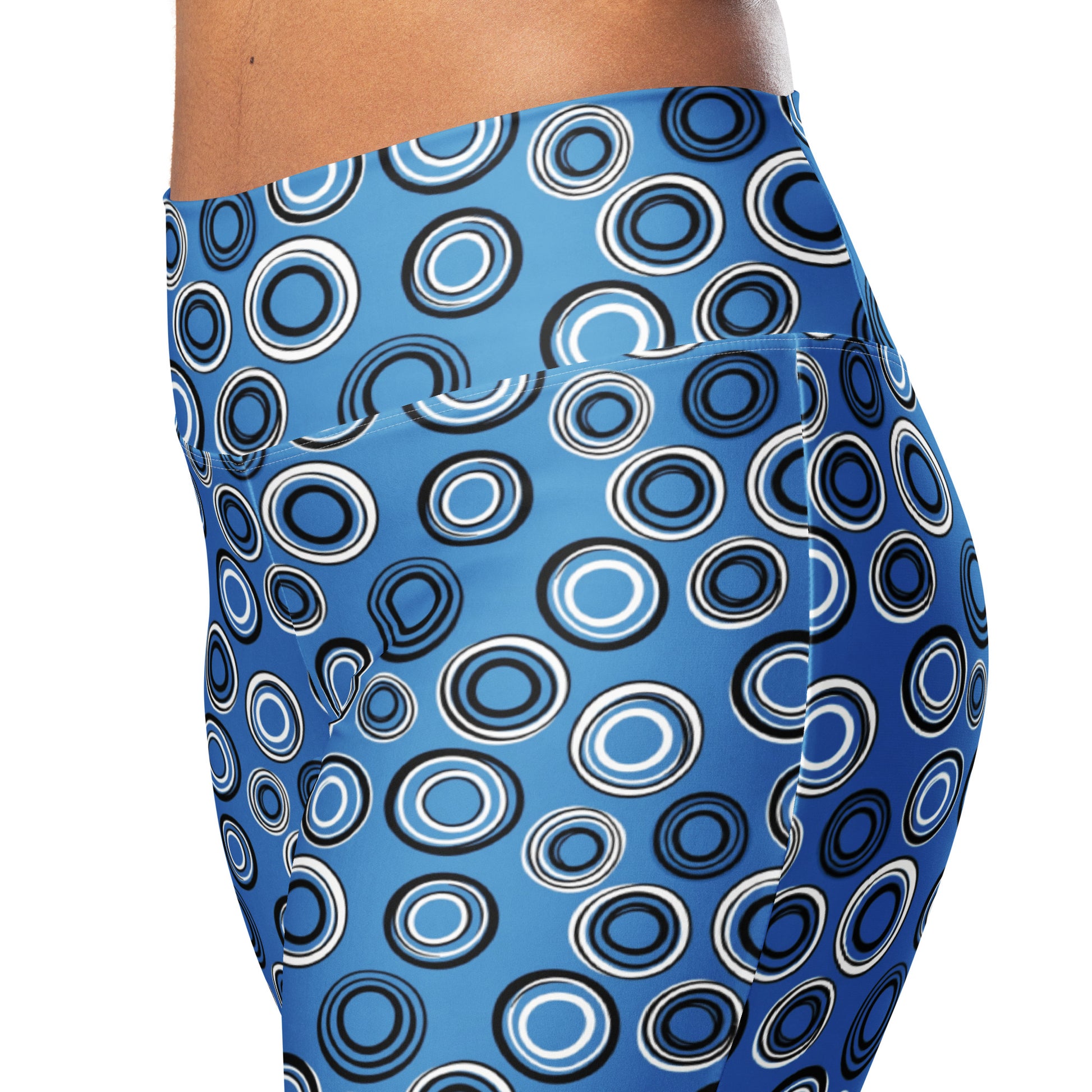 Close-up of a person wearing high-waisted blue leggings with an allover concentric circle pattern in black, white, and blue, against a plain white background. Stylish Celestial Planetary Orbit Pattern Flare Leggings Activewear