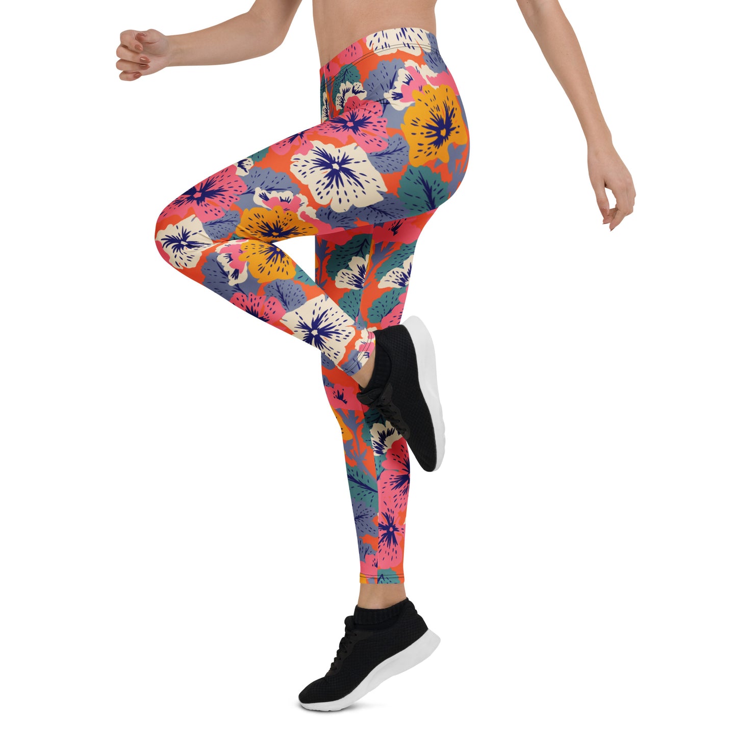 A model wearing high-waisted leggings with a vibrant multicolor floral and tropical print, paired with black athletic sneakers, shown against a plain white background. Stylish Leggings with Floral and Tropical Leaf Motifs