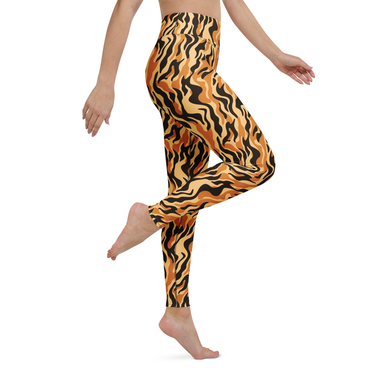 A model wearing high-waisted leggings with a bold orange, black, and yellow wavy tiger-stripe pattern, shown from the waist down against a plain white background. Tiger Print Leggings for Workouts and Everyday Wear