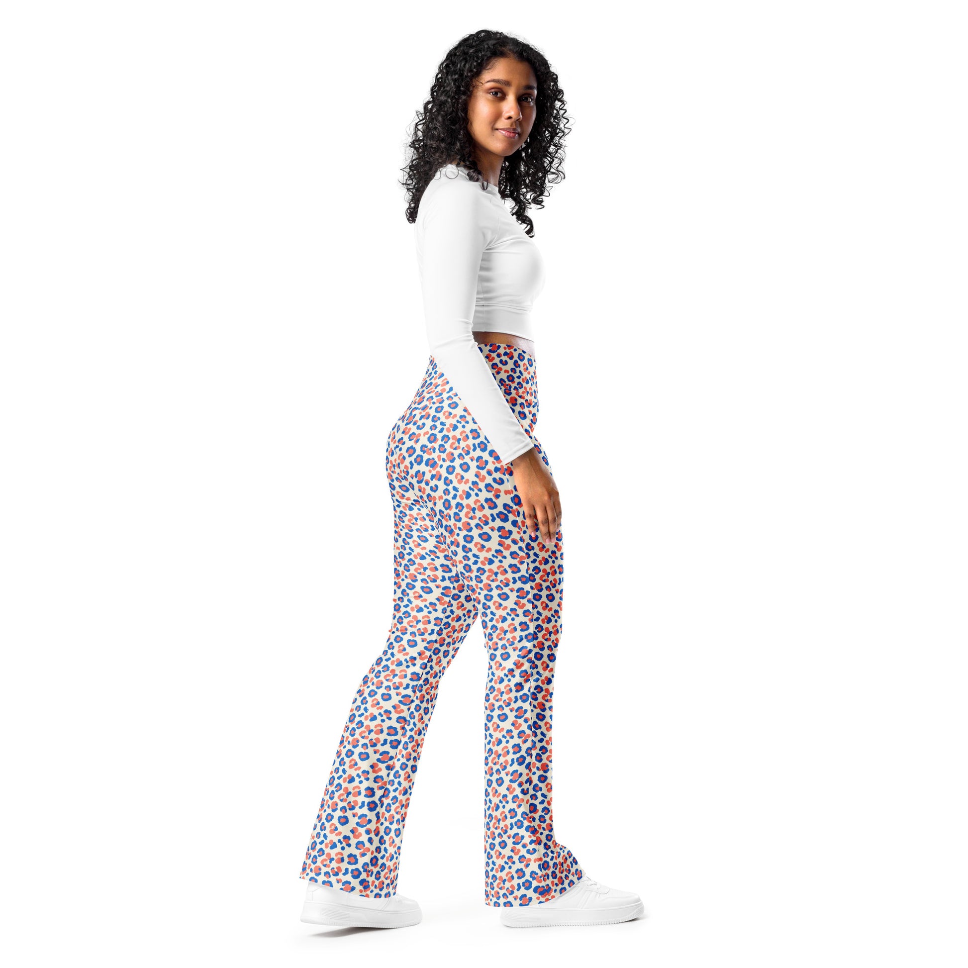 A woman modeling high-waisted, wide-leg pants with a vibrant blue and orange circular pattern, paired with a white long-sleeve crop top and white sneakers, set against a solid white background. Trendy Colorful Leopard Print Flare Leggings Active Wear