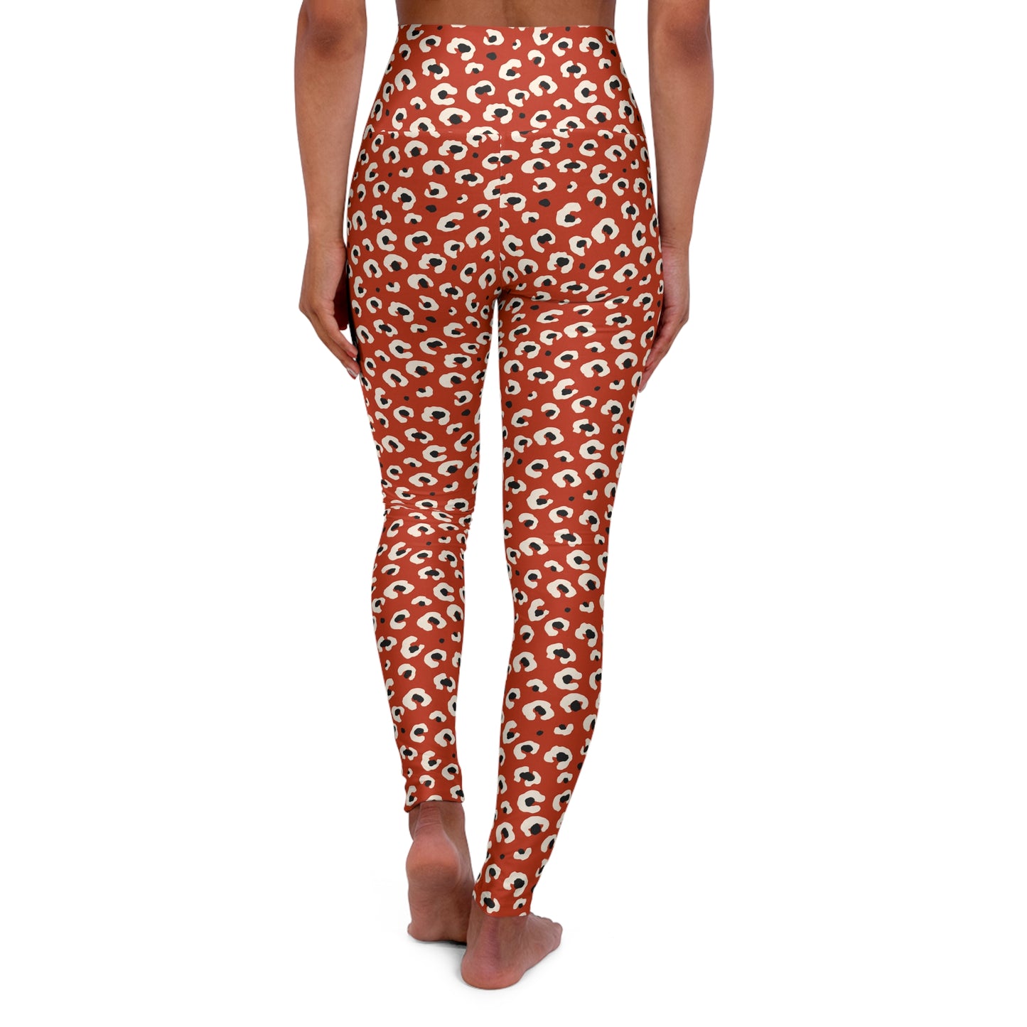 Rear view of a model wearing high-waisted leggings with an all-over repeating eye print on a rust-orange background, shown against a plain white studio background. Tropical Leopard Print High-Waisted Yoga Leggings Activewear