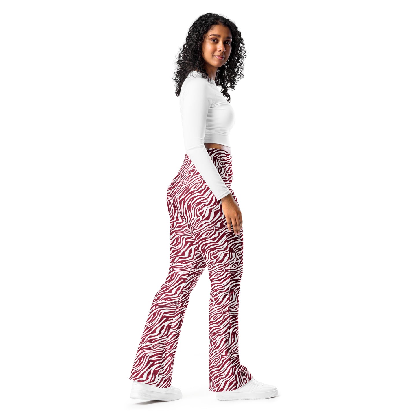 A woman modeling a pair of high-waisted, wide-leg pants with a red and white zebra print, paired with a white long-sleeve crop top and white sneakers, set against a plain white background. Vintage Comfortable Bold Red Zebra Print Flare Leggings Activewear
