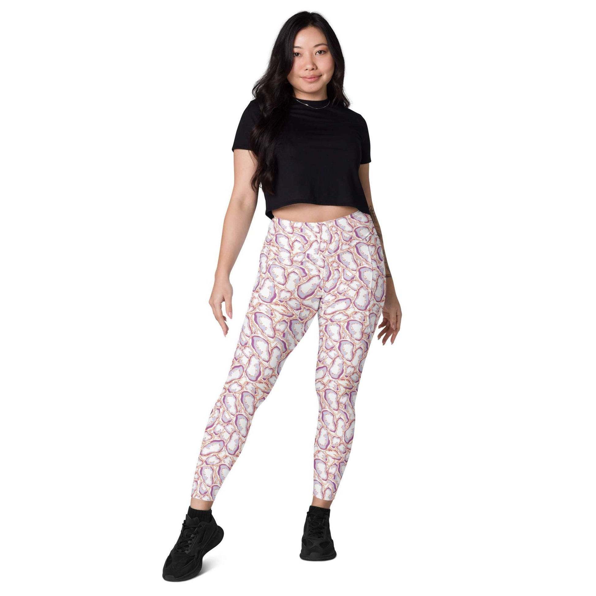 A woman modeling high-waisted leggings with a pink, white, and orange paisley pattern, paired with a black crop top and black sneakers, against a solid white background. Elegant Organic Marble Stone Leggings with Pockets Activewear Shop Elegant Organic Marble Stone Leggings with Pockets, designed for all-day comfort, flexible movement, and standout style. Elevate your activewear with Elegant Organic Marble Stone Leggings with Pockets, blending bold marble style, comfort, and function.