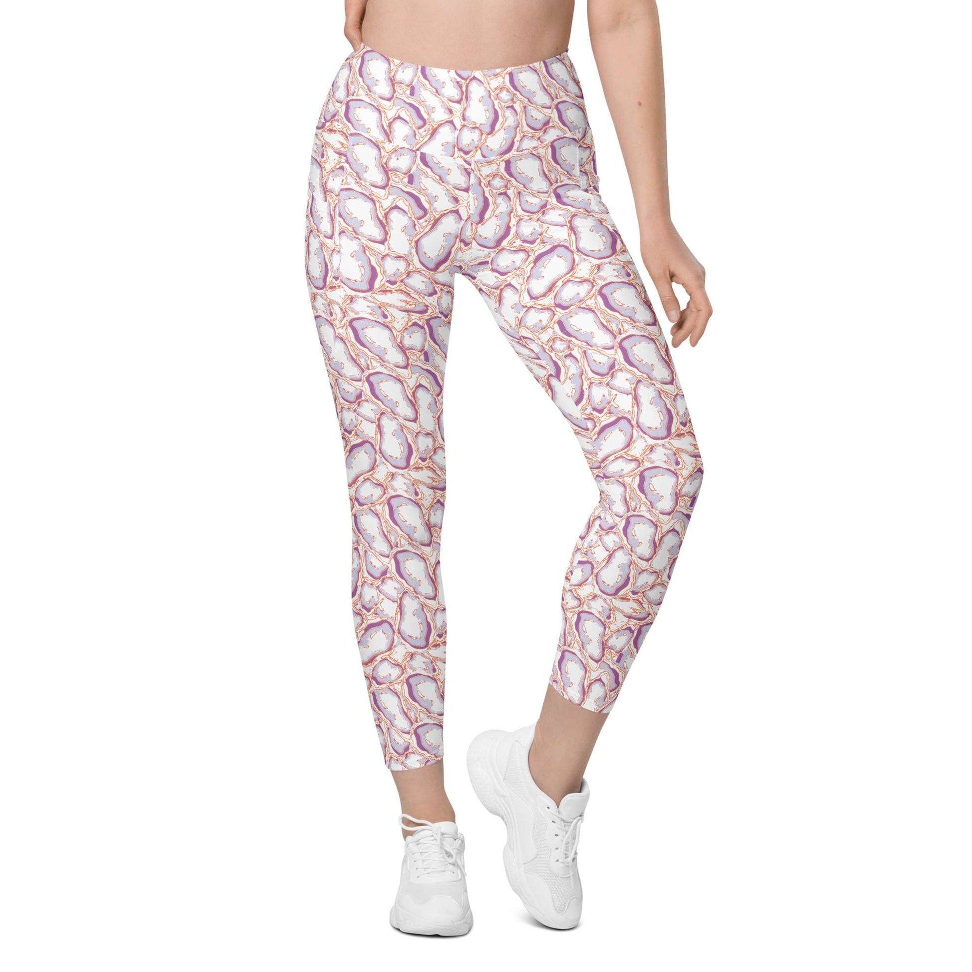 A model from the waist down wearing high-waisted leggings with a pink, purple, and orange geode pattern on a white background, paired with white sneakers. Elegant Organic Marble Stone Leggings with Pockets Activewear Shop Elegant Organic Marble Stone Leggings with Pockets, designed for all-day comfort, flexible movement, and standout style. Elevate your activewear with Elegant Organic Marble Stone Leggings with Pockets, blending bold marble style, comfort, and function.