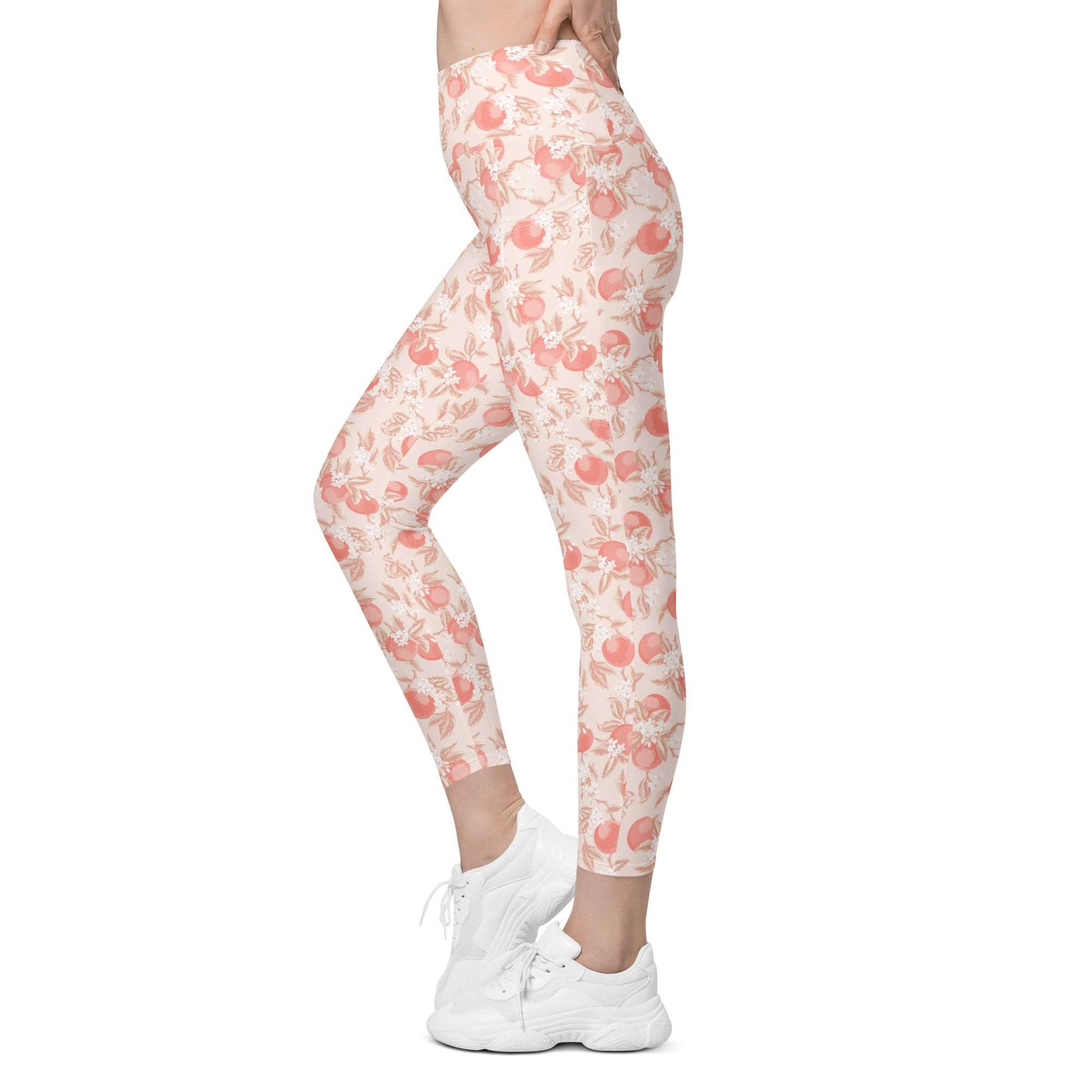A side-profile view of a person wearing high-waisted leggings with a peach and pink floral pattern on a cream background, paired with white sneakers, against a plain white studio background. Artistic Ditsy Floral Print Leggings with Pockets Activewear Artistic Stylized Ditsy Floral Pattern with Blue and Orange Botanical Motifs Leggings with Pockets Activewear Shop Artistic Ditsy Floral Print Leggings with Pockets, designed for bold outfits, flexible movement, and convenient everyday storage.