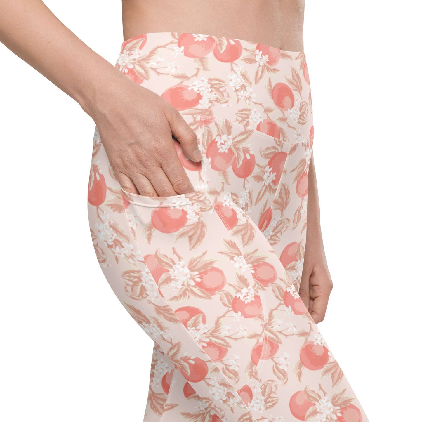 A close-up of a person wearing high-waisted leggings with a peach and white floral print, showing a side pocket being accessed with a hand, on a white background. Artistic Ditsy Floral Print Leggings with Pockets Activewear Artistic Stylized Ditsy Floral Pattern with Blue and Orange Botanical Motifs Leggings with Pockets Activewear Shop Artistic Ditsy Floral Print Leggings with Pockets, designed for bold outfits, flexible movement, and convenient everyday storage.