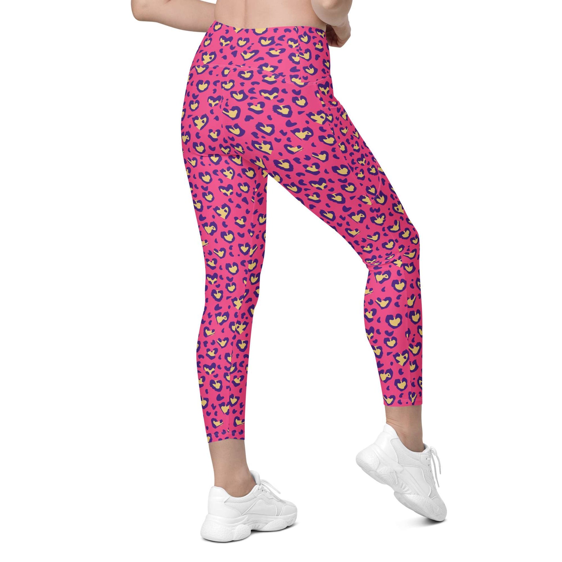 Pink leopard-print leggings with a colorful heart pattern, shown on a model from the waist down wearing white sneakers against a plain white background. Heart Pink Leopard Pattern Leggings with Pockets Activewear Shop Heart Pink Leopard Pattern Leggings with Pockets Activewear, designed for bold workouts, everyday comfort, and convenient storage. Upgrade your workout wardrobe with Heart Pink Leopard Pattern Leggings with Pockets Activewear—stylish, practical, and made to move.