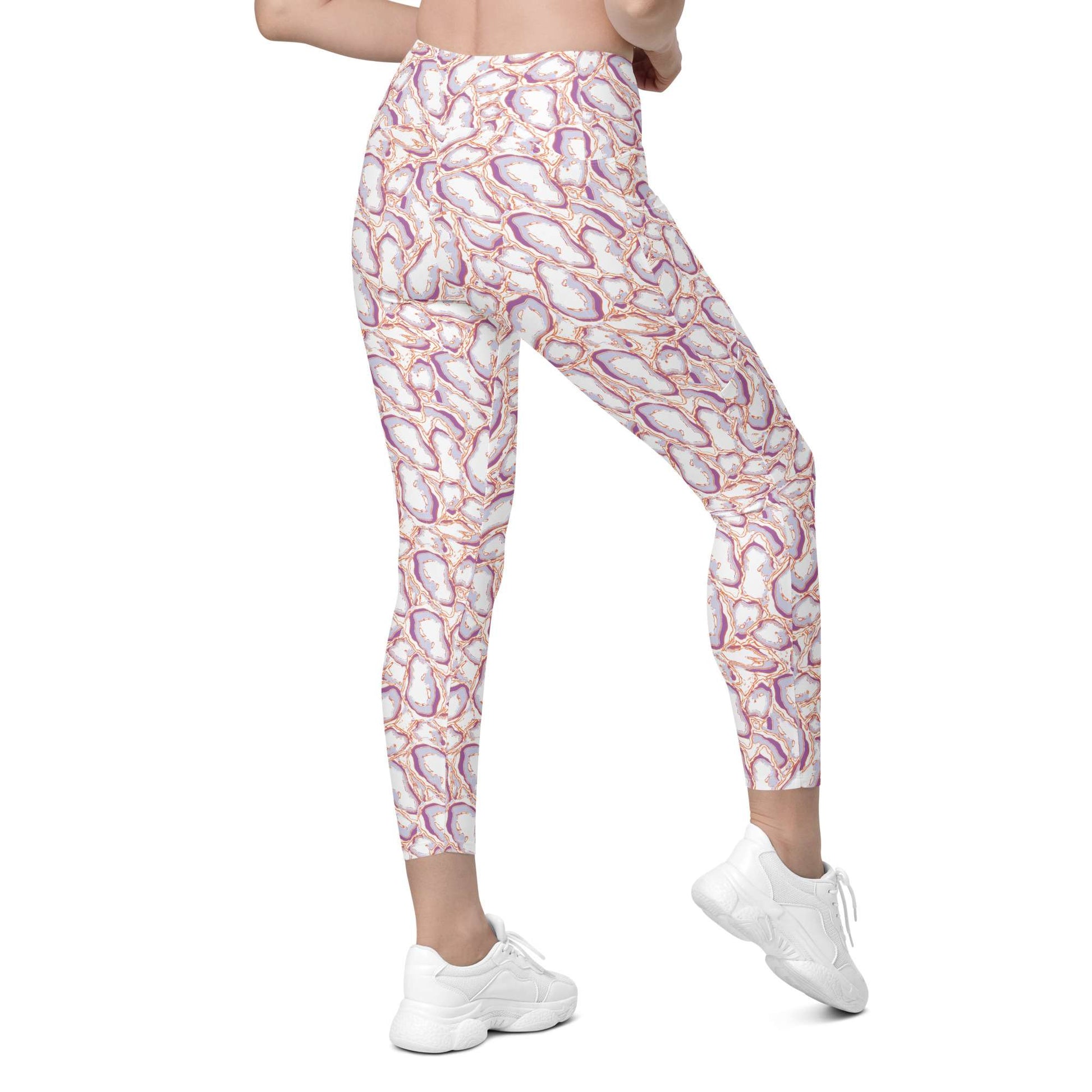 A model from the waist down wearing high-waisted leggings with a white base and a colorful abstract pattern in purple, orange, and pink, paired with white sneakers on a white background. Elegant Organic Marble Stone Leggings with Pockets Activewear Shop Elegant Organic Marble Stone Leggings with Pockets, designed for all-day comfort, flexible movement, and standout style. Elevate your activewear with Elegant Organic Marble Stone Leggings with Pockets, blending bold marble style, comfort, and function.