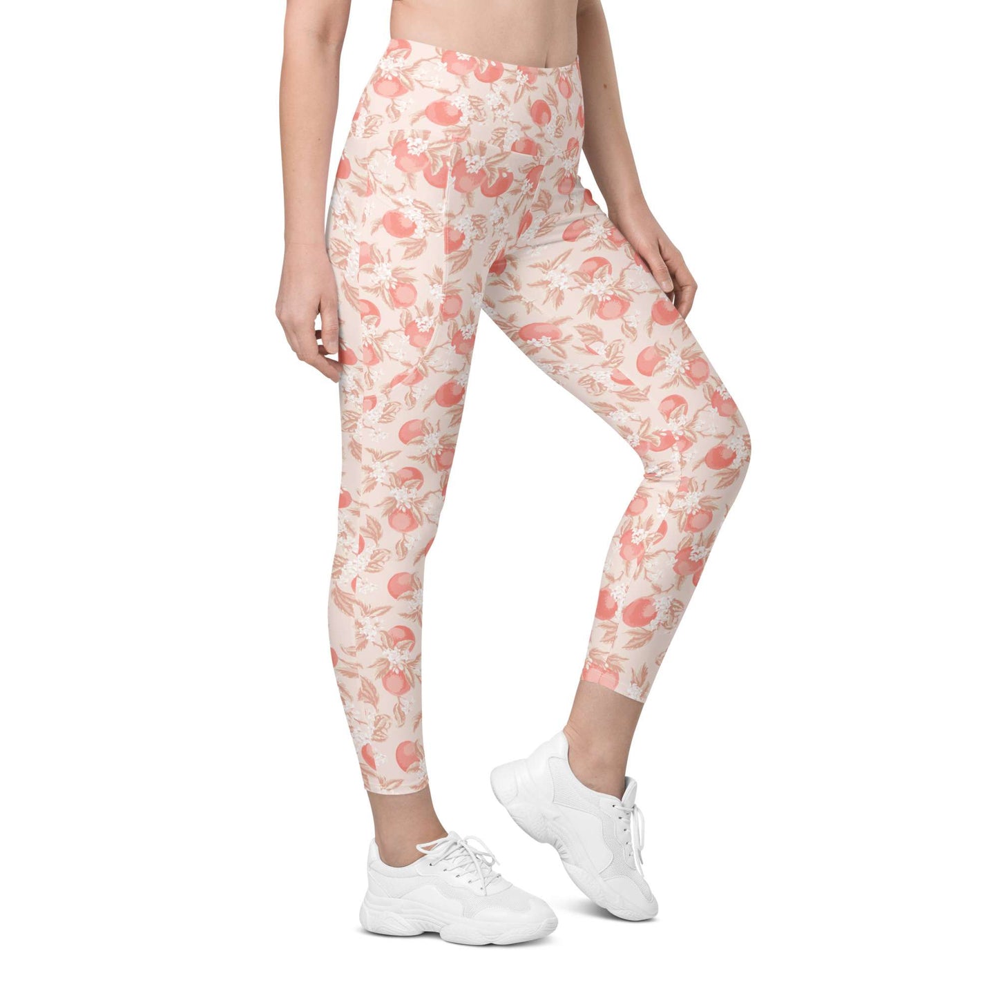 A model wearing high-waisted leggings with a peach and pink floral pattern on a cream background, paired with white sneakers, shown against a plain white studio background. Artistic Ditsy Floral Print Leggings with Pockets Activewear Artistic Stylized Ditsy Floral Pattern with Blue and Orange Botanical Motifs Leggings with Pockets Activewear Shop Artistic Ditsy Floral Print Leggings with Pockets, designed for bold outfits, flexible movement, and convenient everyday storage.